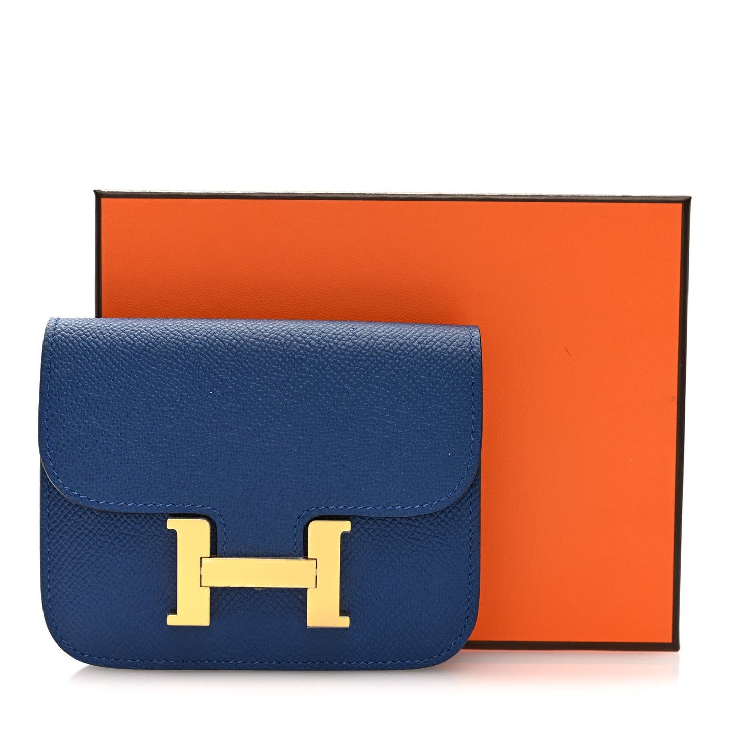 Blue Epsom leather slim wallet with gold H logo clasp beside orange box