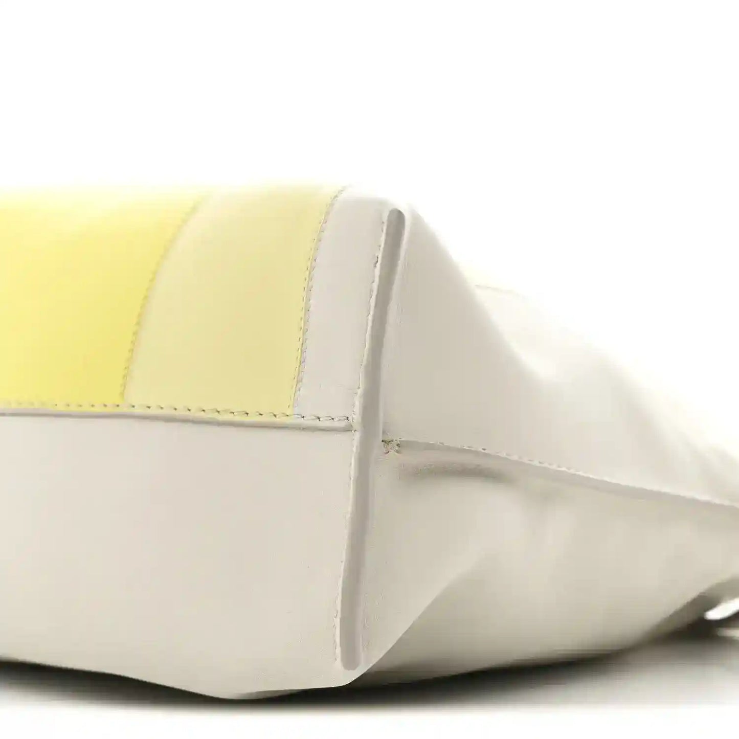 Close-up of pale grey and light citrine panels with curved front seam on clutch