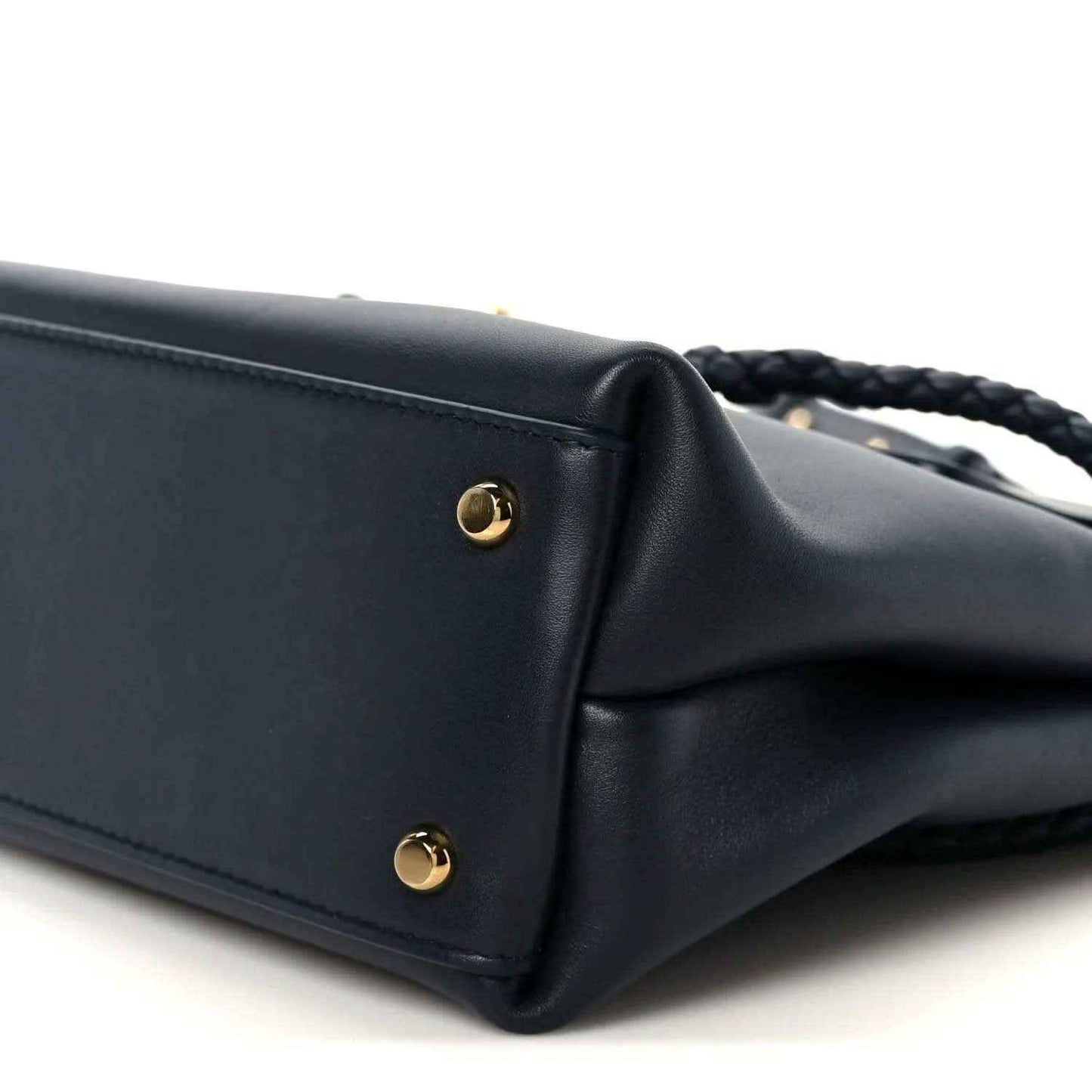 Small black leather handbag corner with gold stud hardware