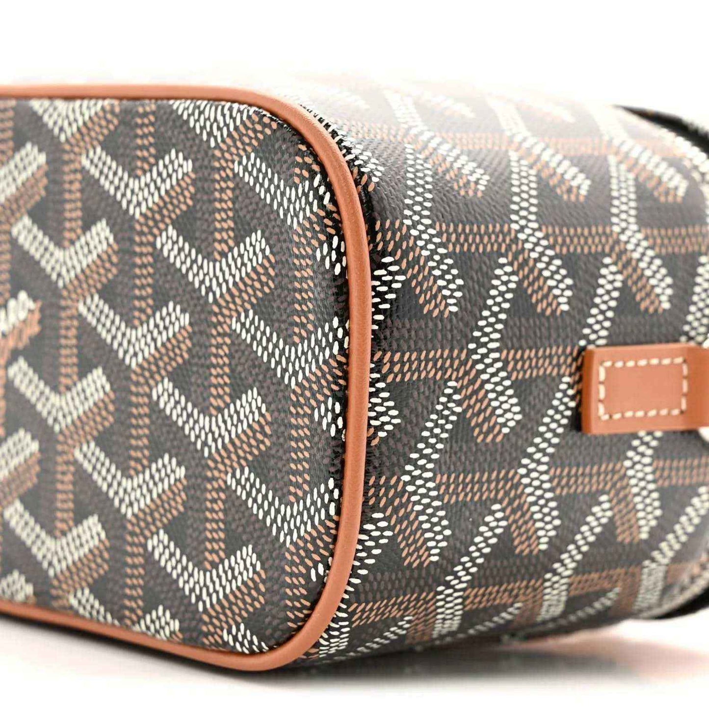 Mini vanity case close-up of side panel; dark monogram canvas with tan leather piping