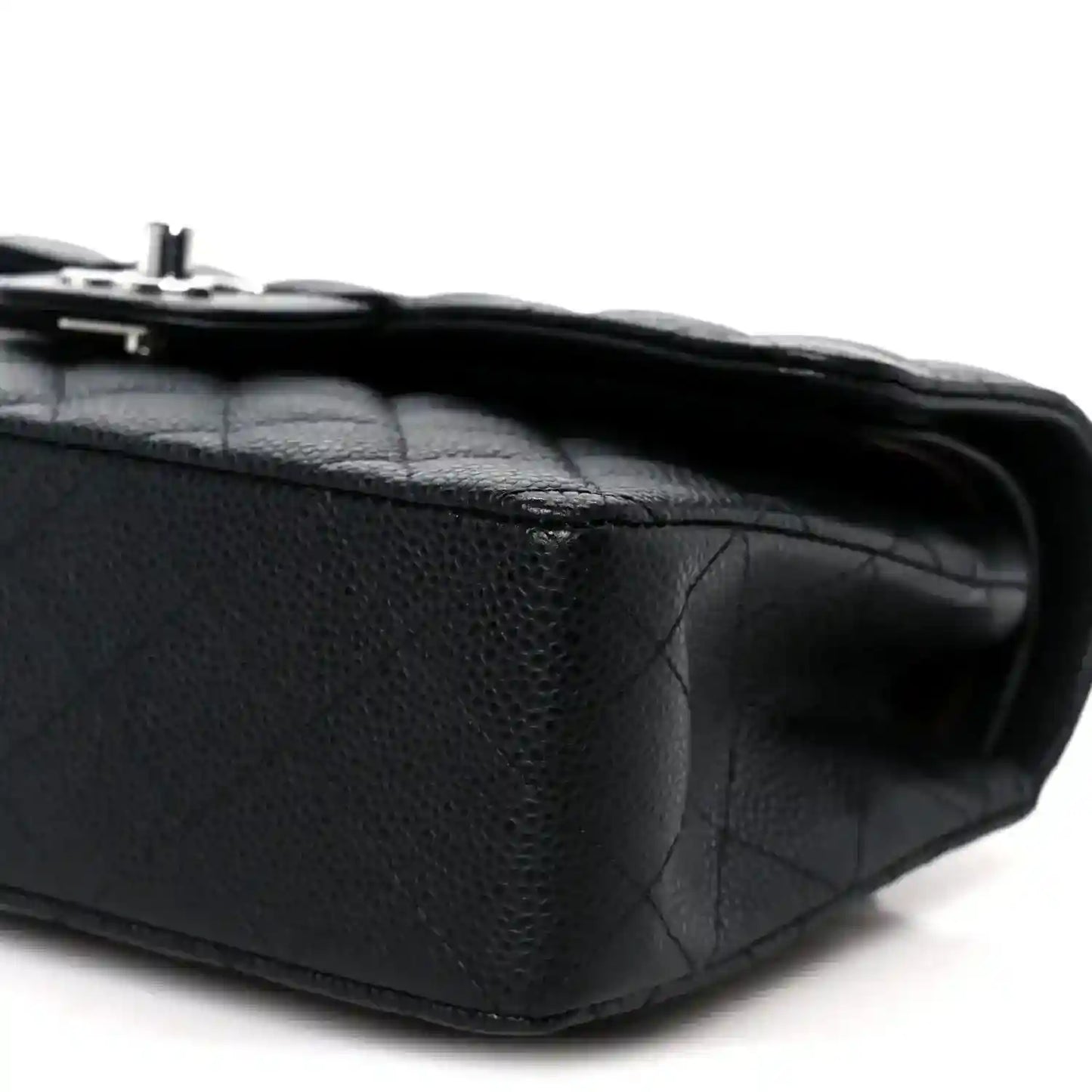 Black caviar-quilted leather flap bag corner detail with turn-lock hardware
