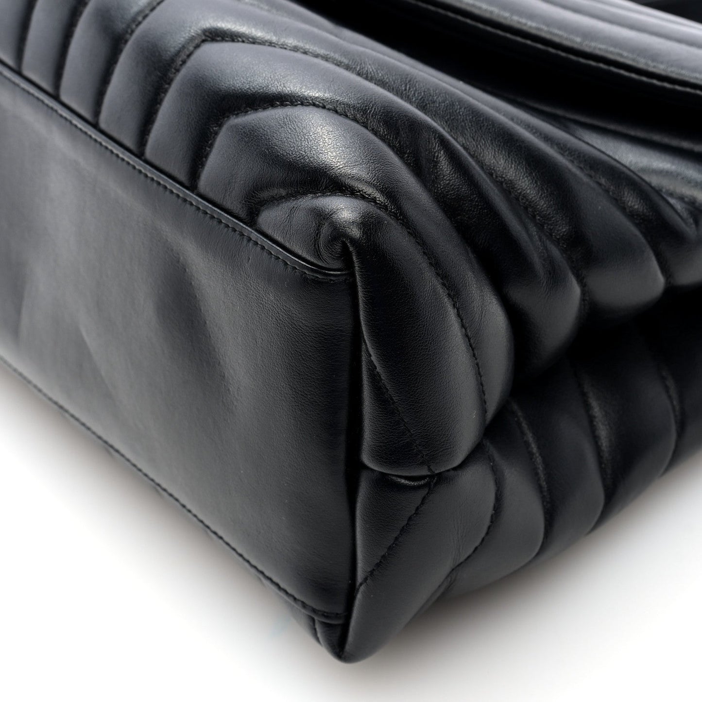 Black quilted satchel close-up of stitched handle and padded leather edge