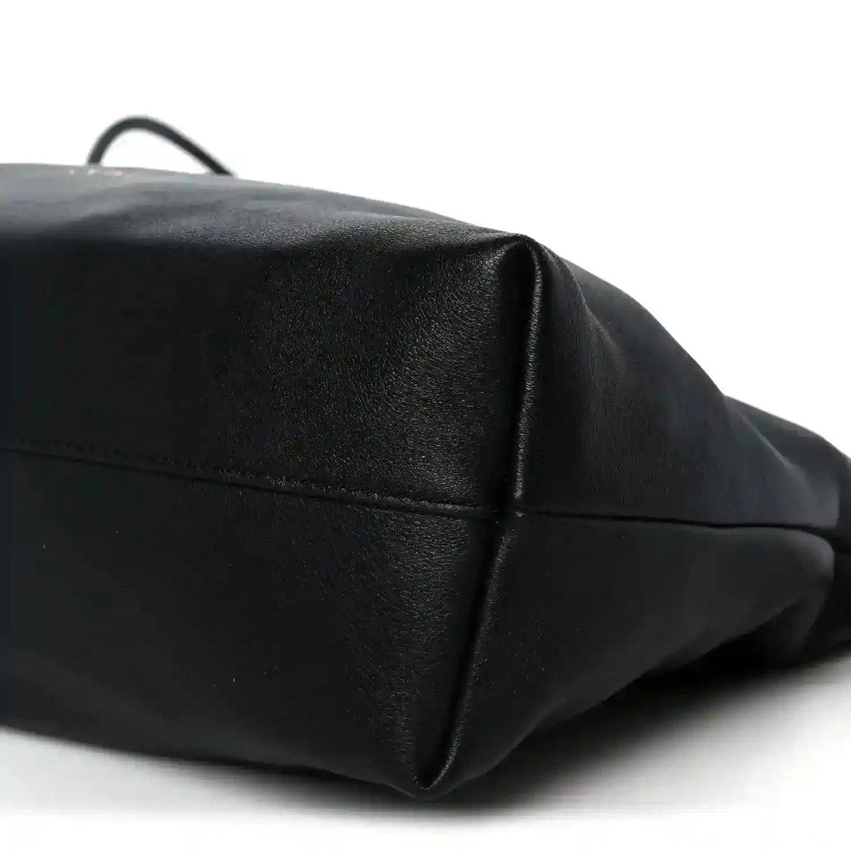 Black leather clutch corner view with top edge seam and subtle pebbled texture.
