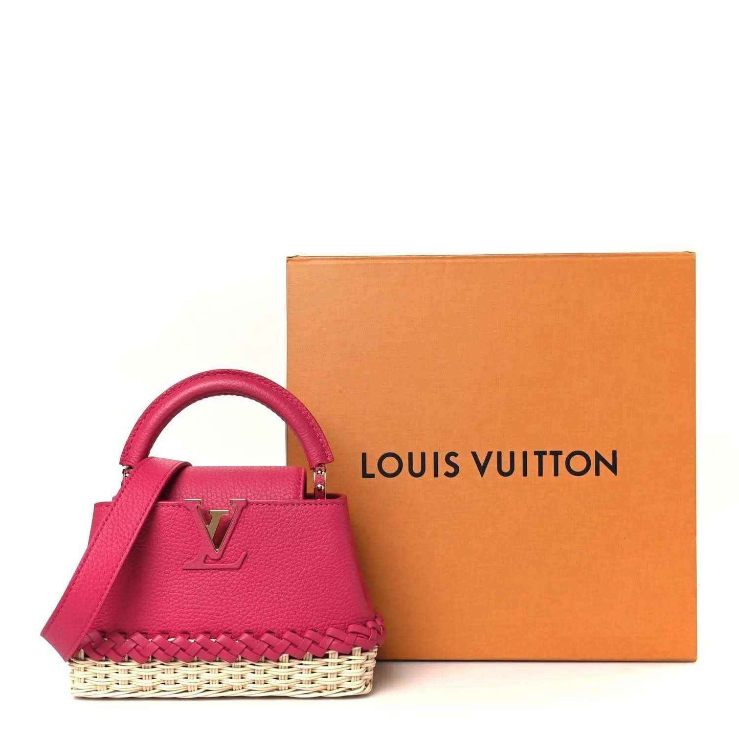 Magenta mini handbag with rattan base and top handle, with Louis Vuitton box nearby