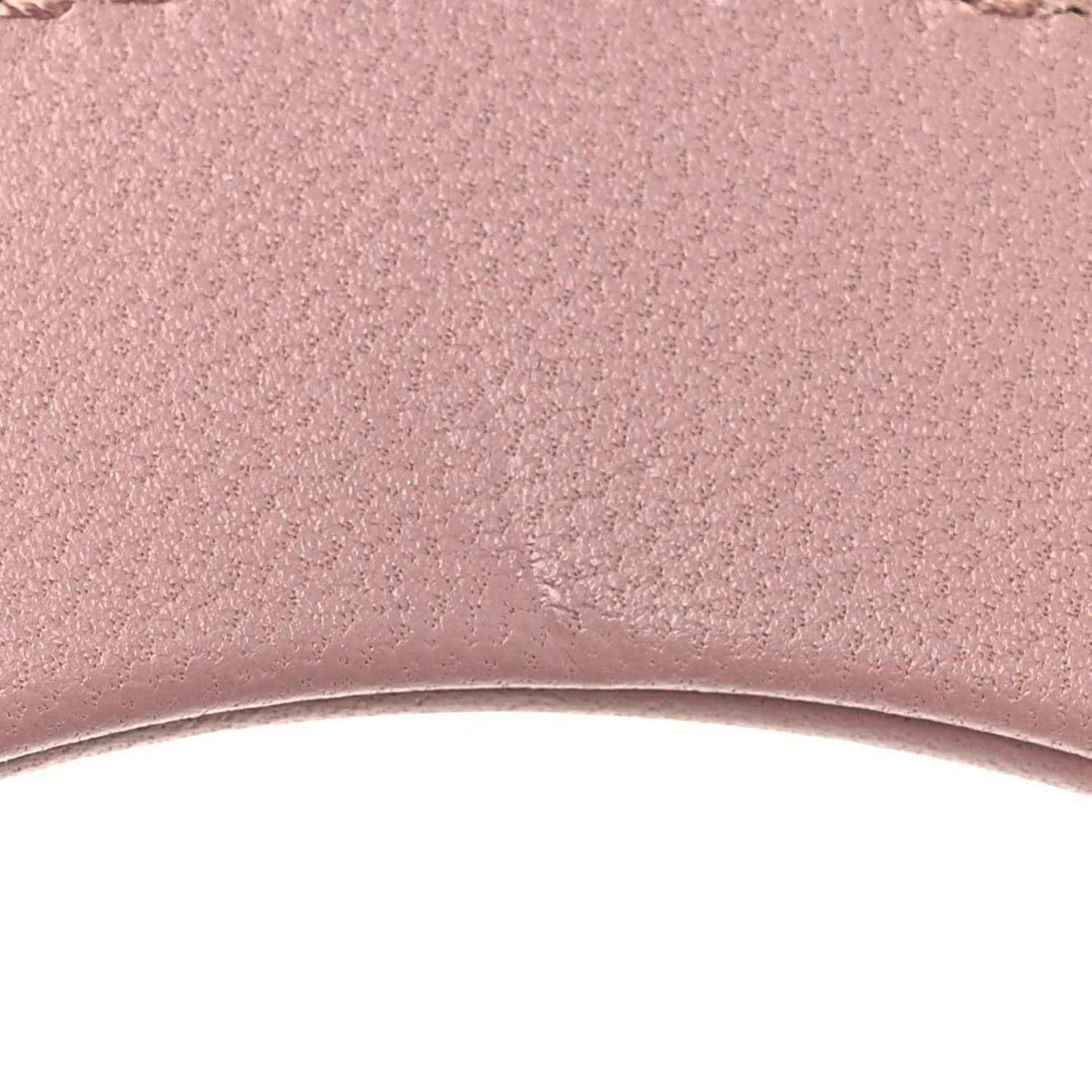 Mini Lady Dior lambskin handbag, pink leather texture close-up with fine grain
