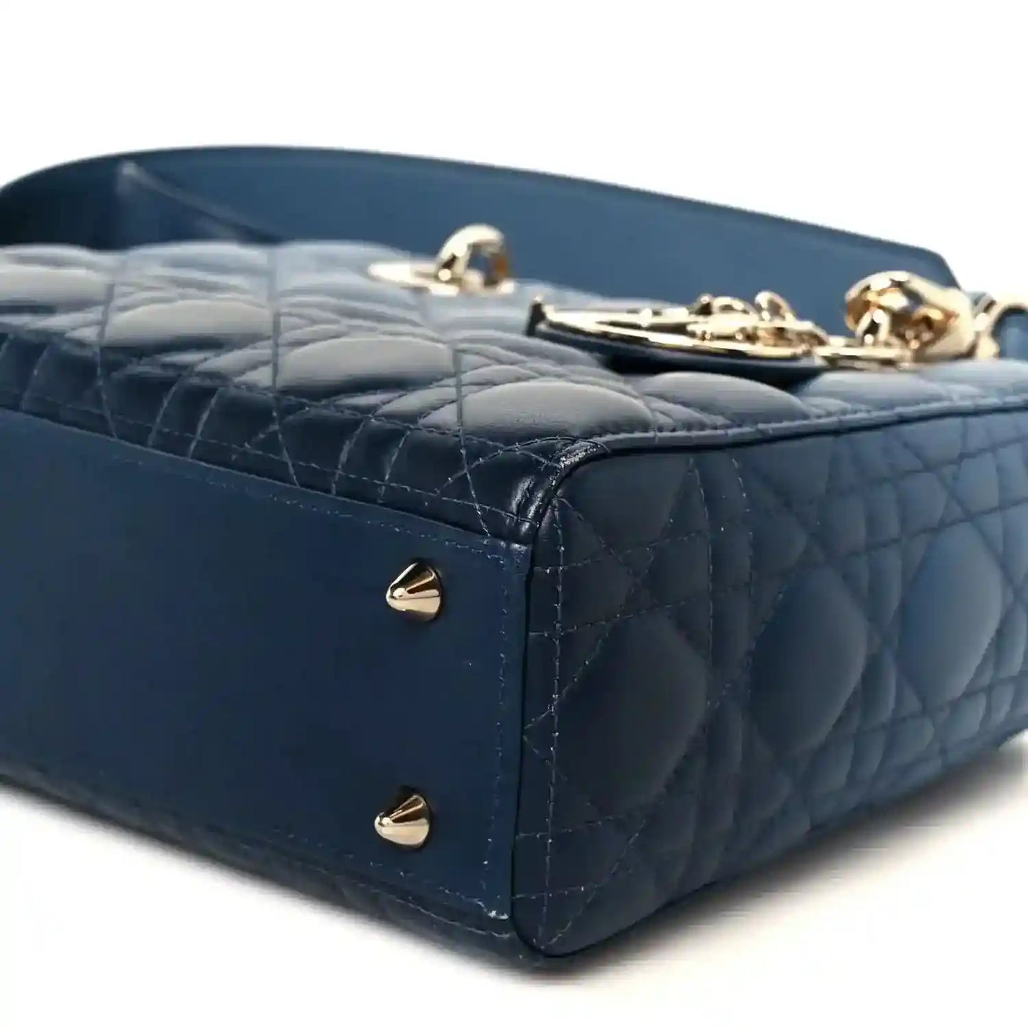 Indigo blue quilted leather handbag side panel with gold studs and top handle base