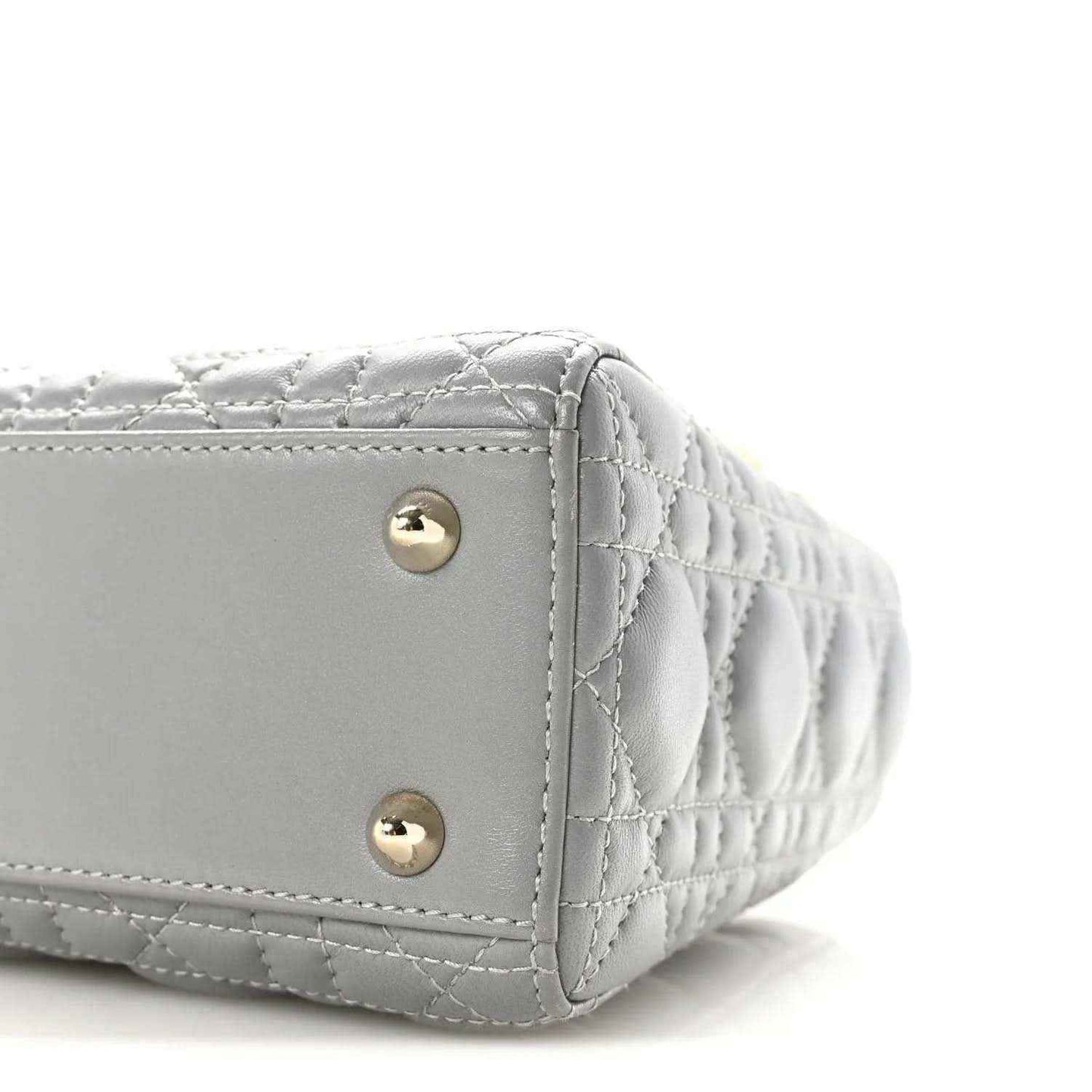 Grey quilted Lady Dior handbag side corner with gold snap buttons and curved shape