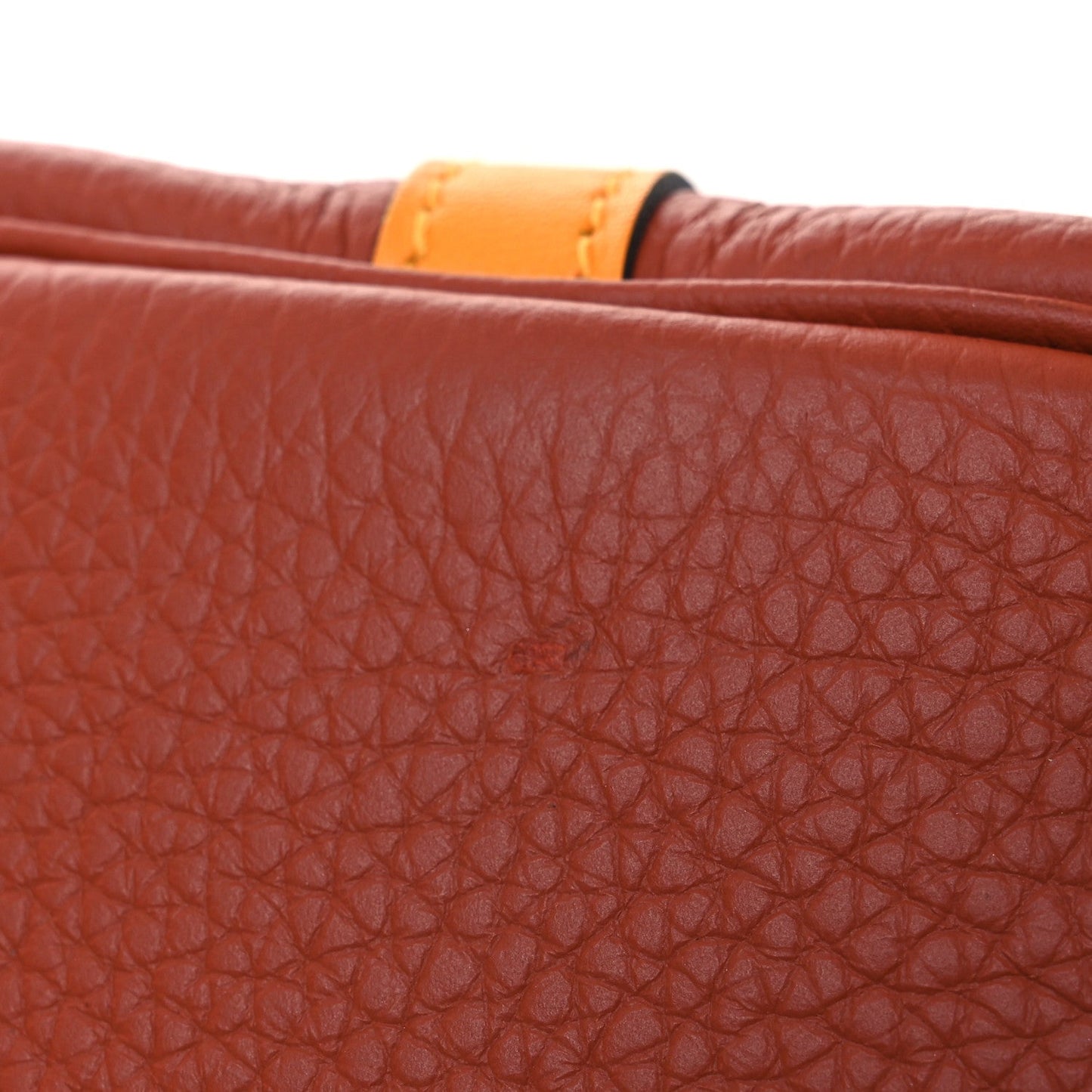 Red leather tote panel with copper-orange trim along the top edge