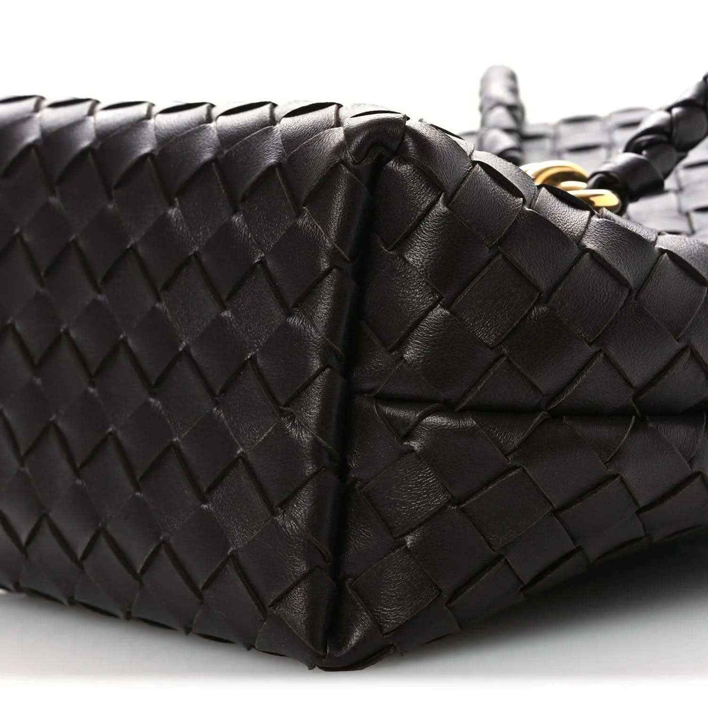 Intrecciato leather bucket bag close-up, dark color, woven panels and handle seam
