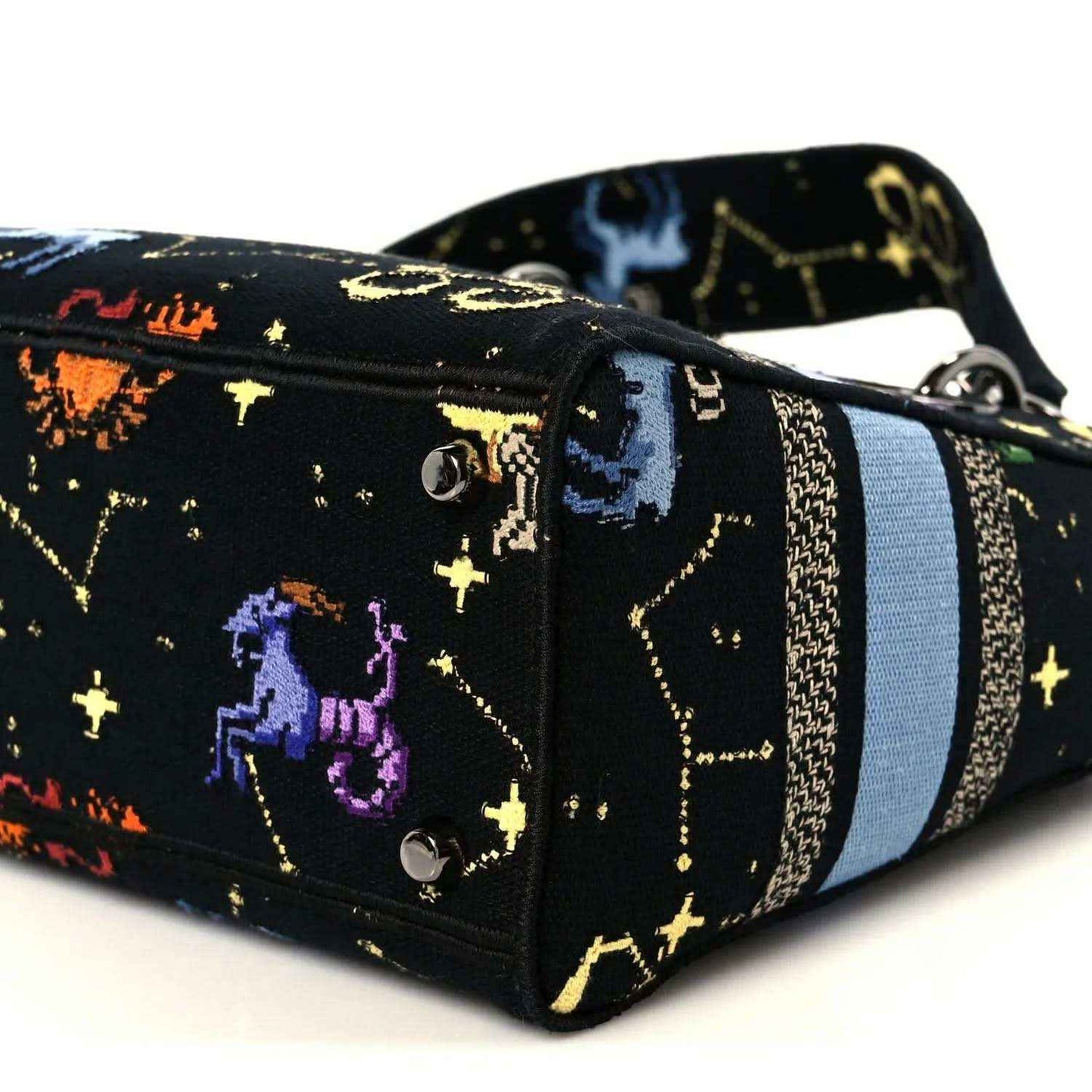 Side view of medium handbag with zodiac pixel print, blue stripe, and silver-tone hardware