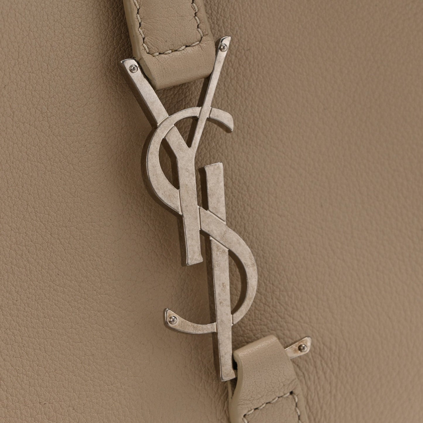 YSL metal logo and hanging leather tag on sea-salt beige hobo bag