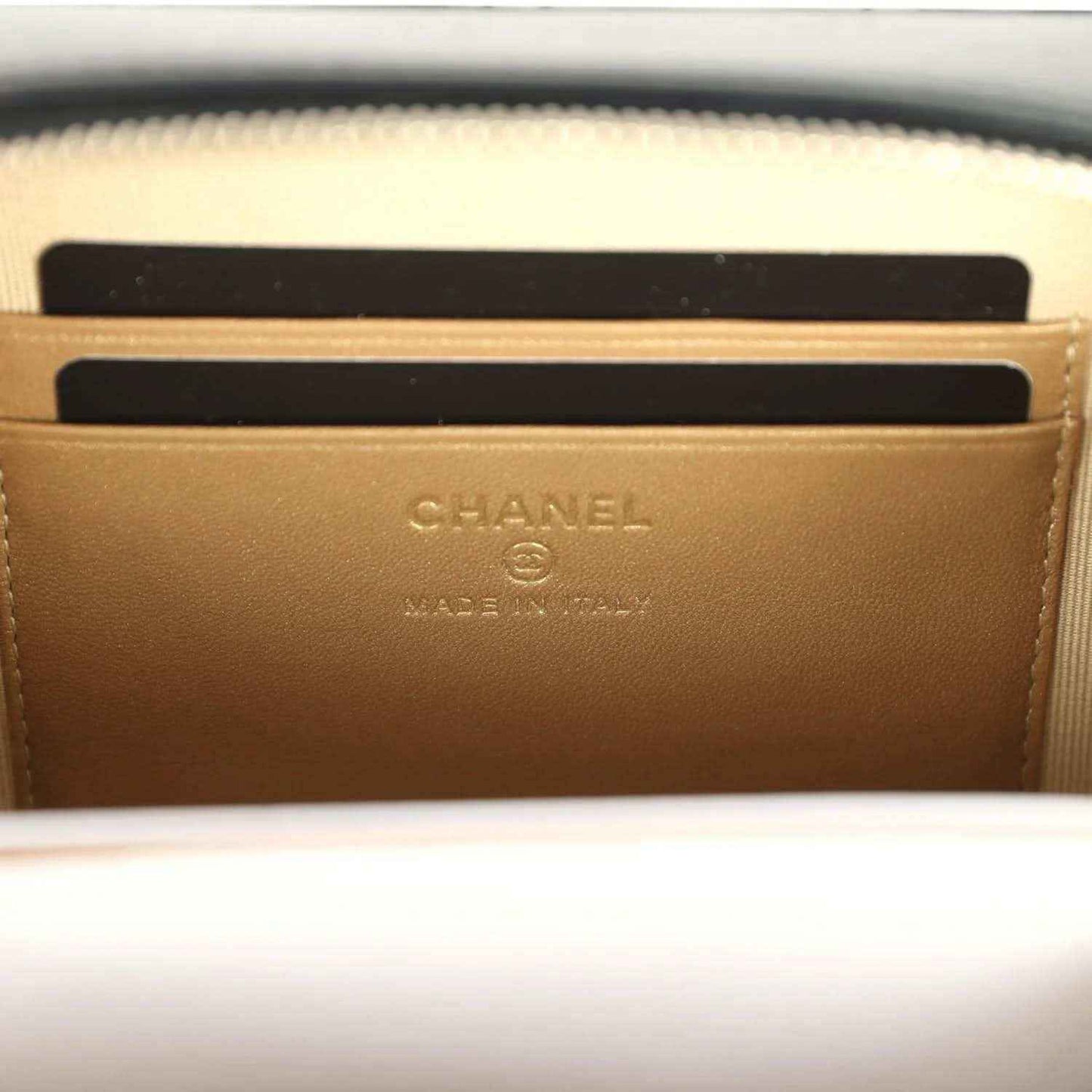 Chanel logo stamp on beige lining inside clutch, with zip opening edge