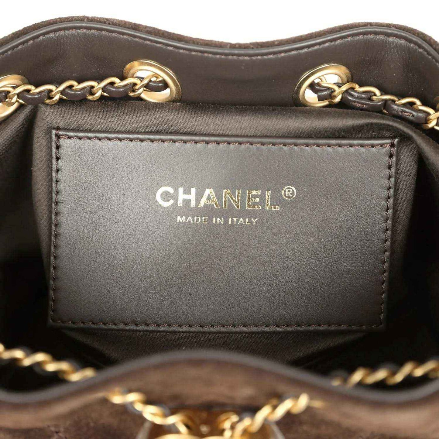 Mini hobo bag interior label reading CHANEL and Made in Italy on gray lining.