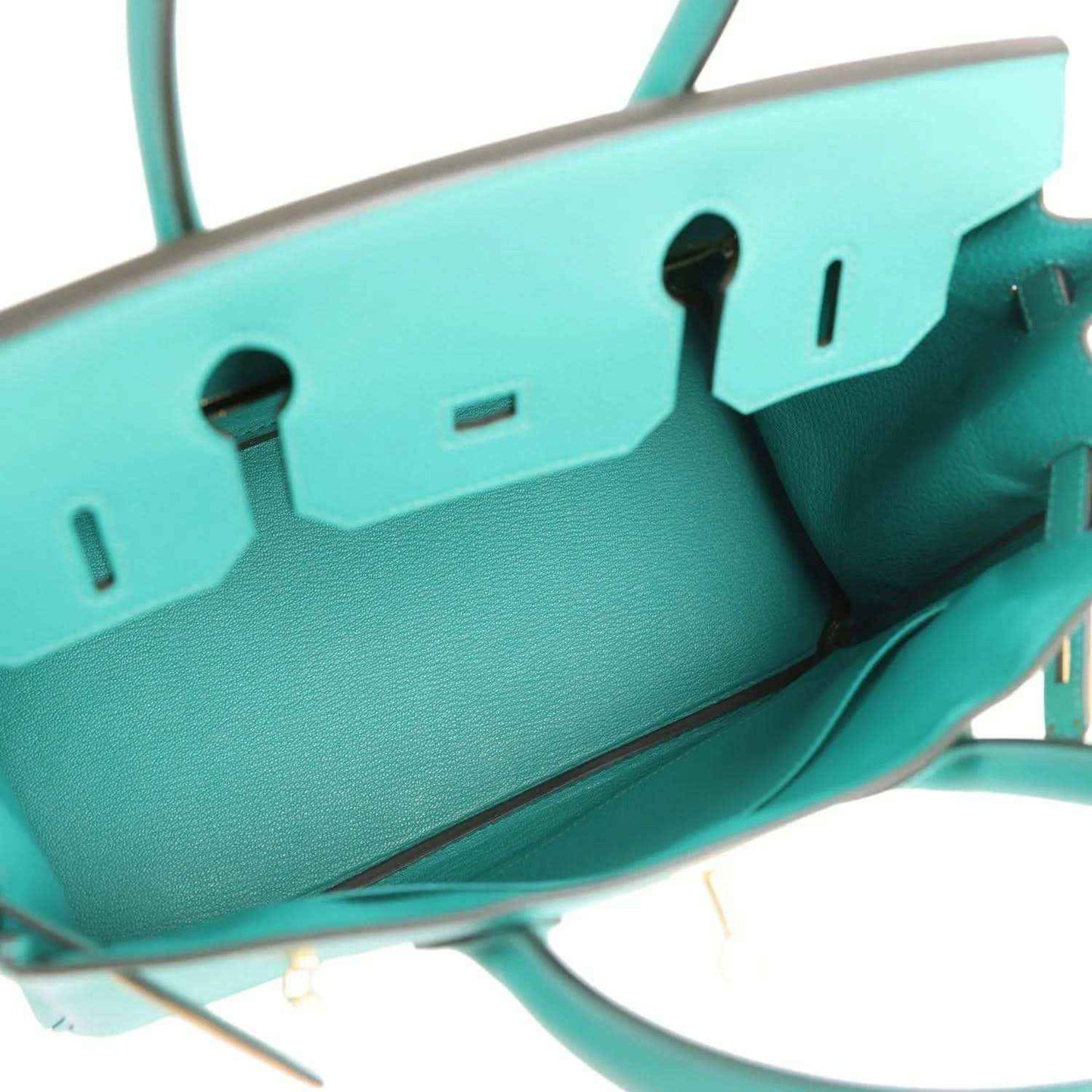 Green leather handbag interior zipper track with gold-tone trim and stitching