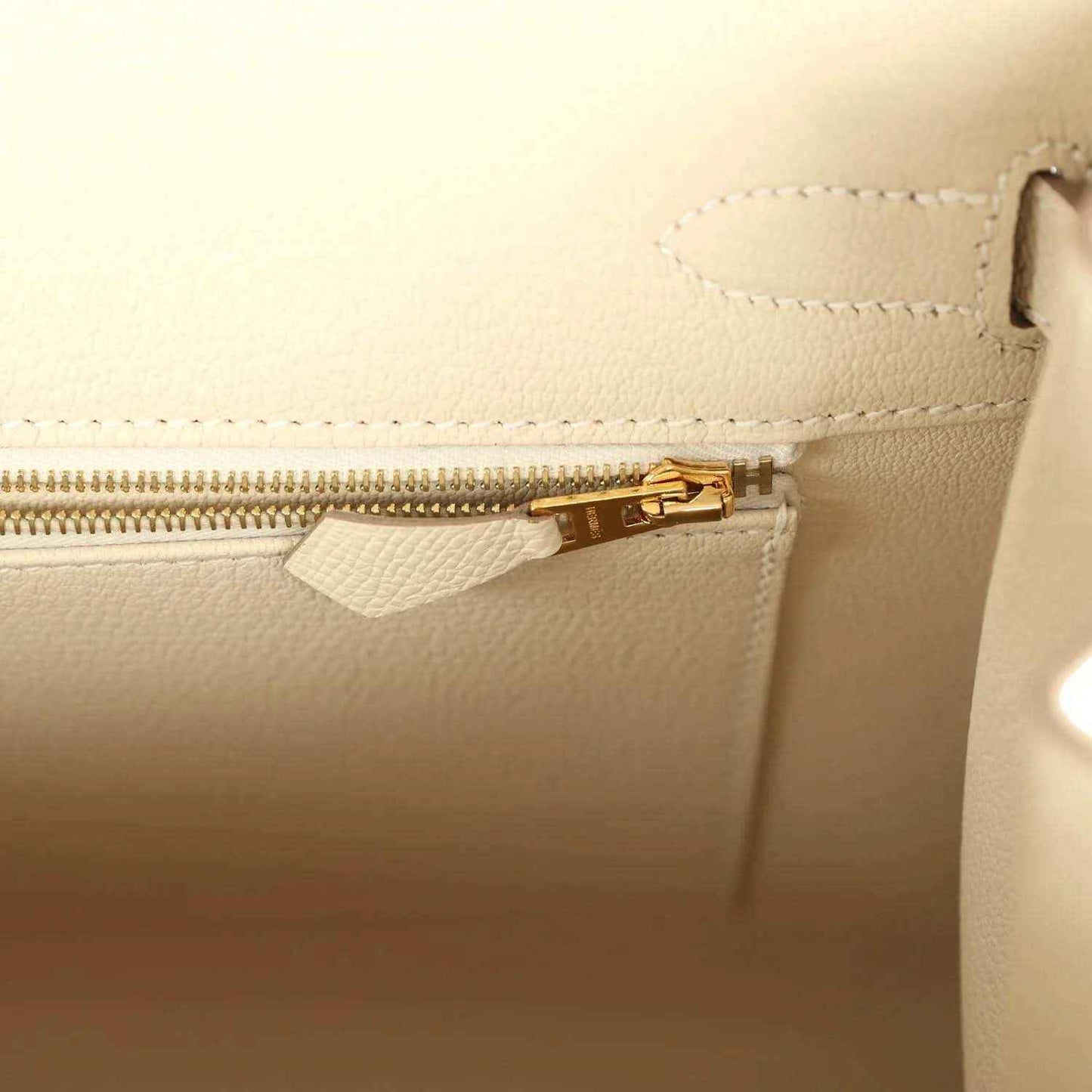 Light cream leather handbag with gold zipper and inner pocket opening