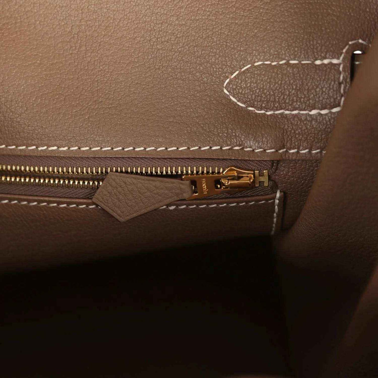 Birkin interior zipper with gold-tone pull tab on taupe Togo leather.
