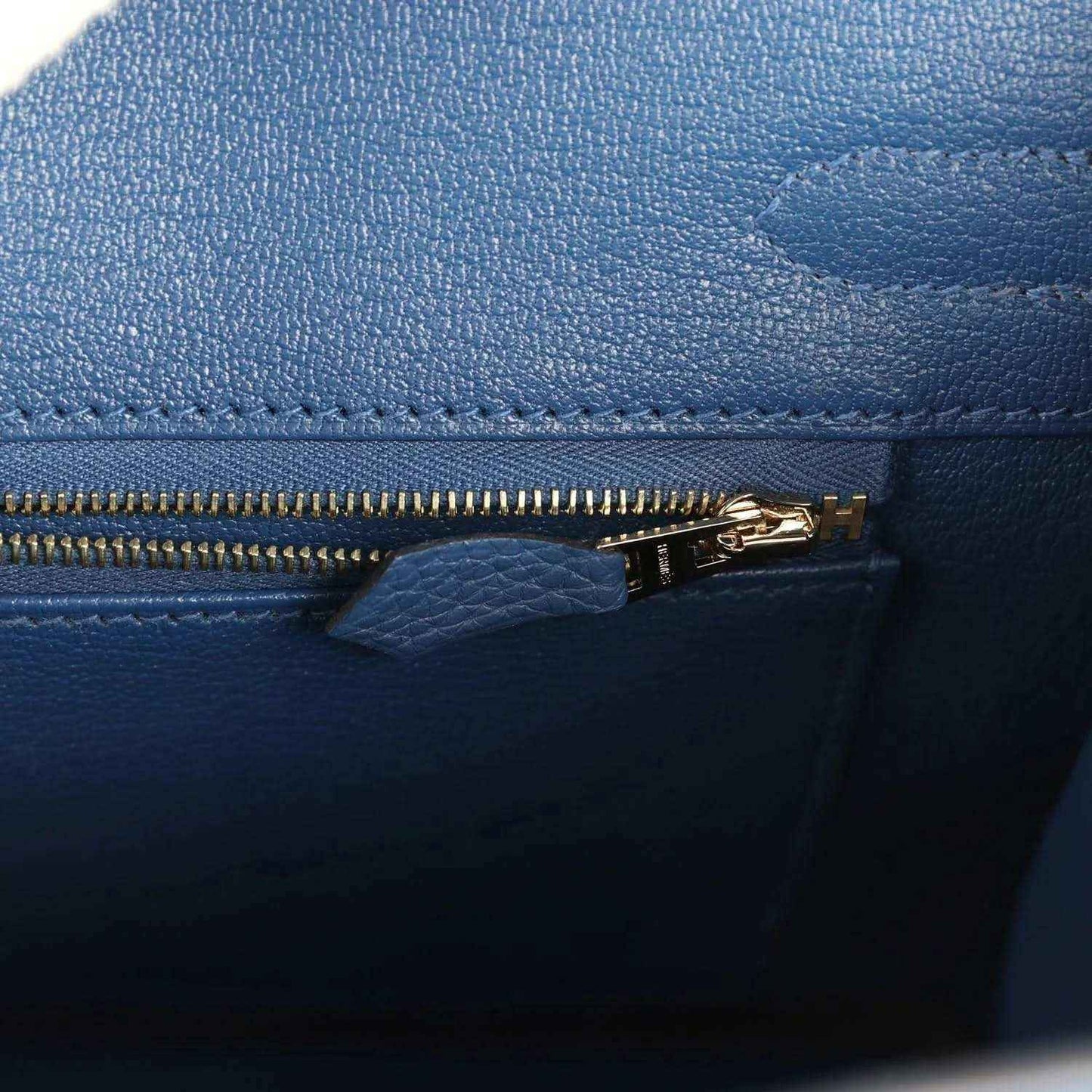 Blue Birkin 30 handbag zipper pull with gold-tone hardware and stitched trim