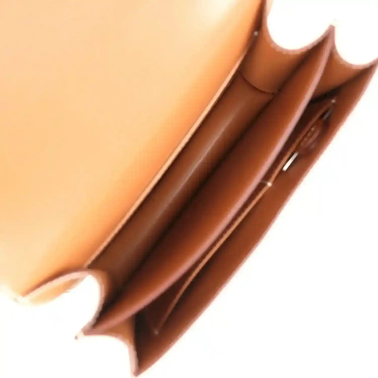 Brown leather mini handbag interior close-up with side seam and lining edges
