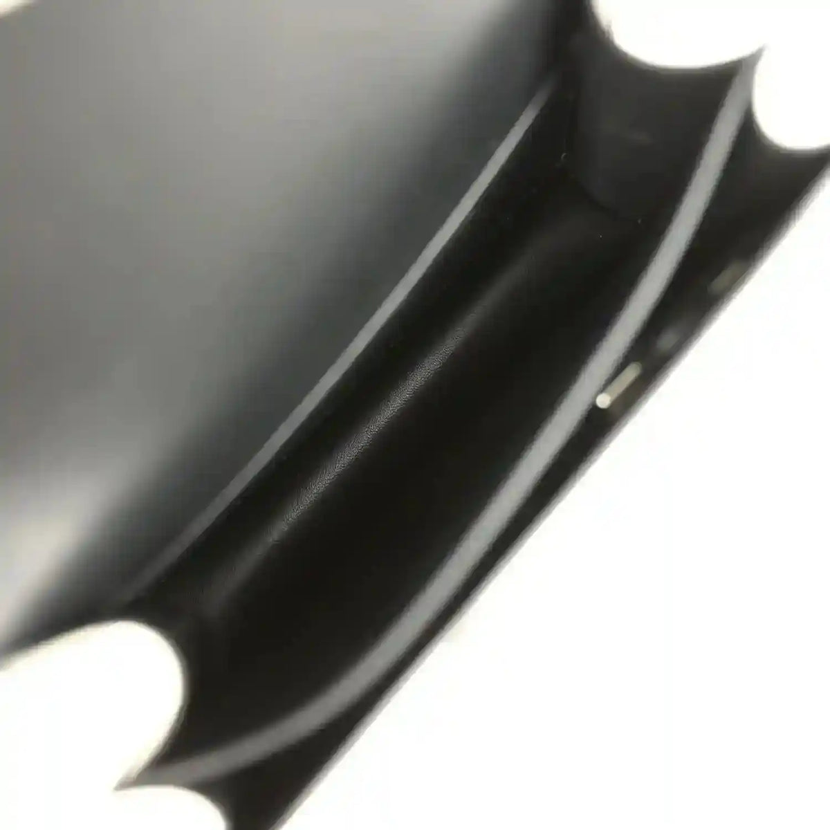 Black calfskin interior close-up with seam and edge trim.
