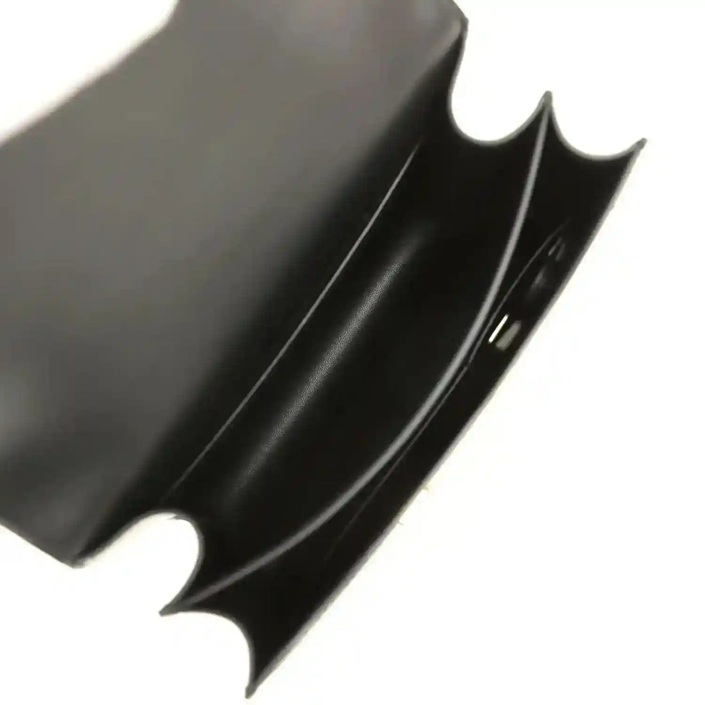 Black leather handbag interior corner with curved cutout and smooth lining
