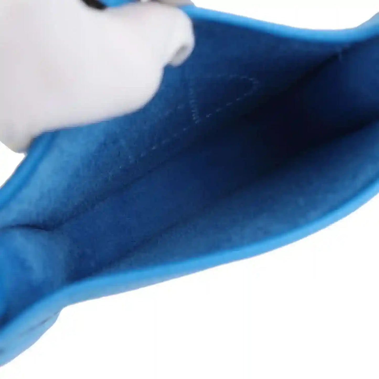 Blue leather bag interior lining shown through the side opening.
