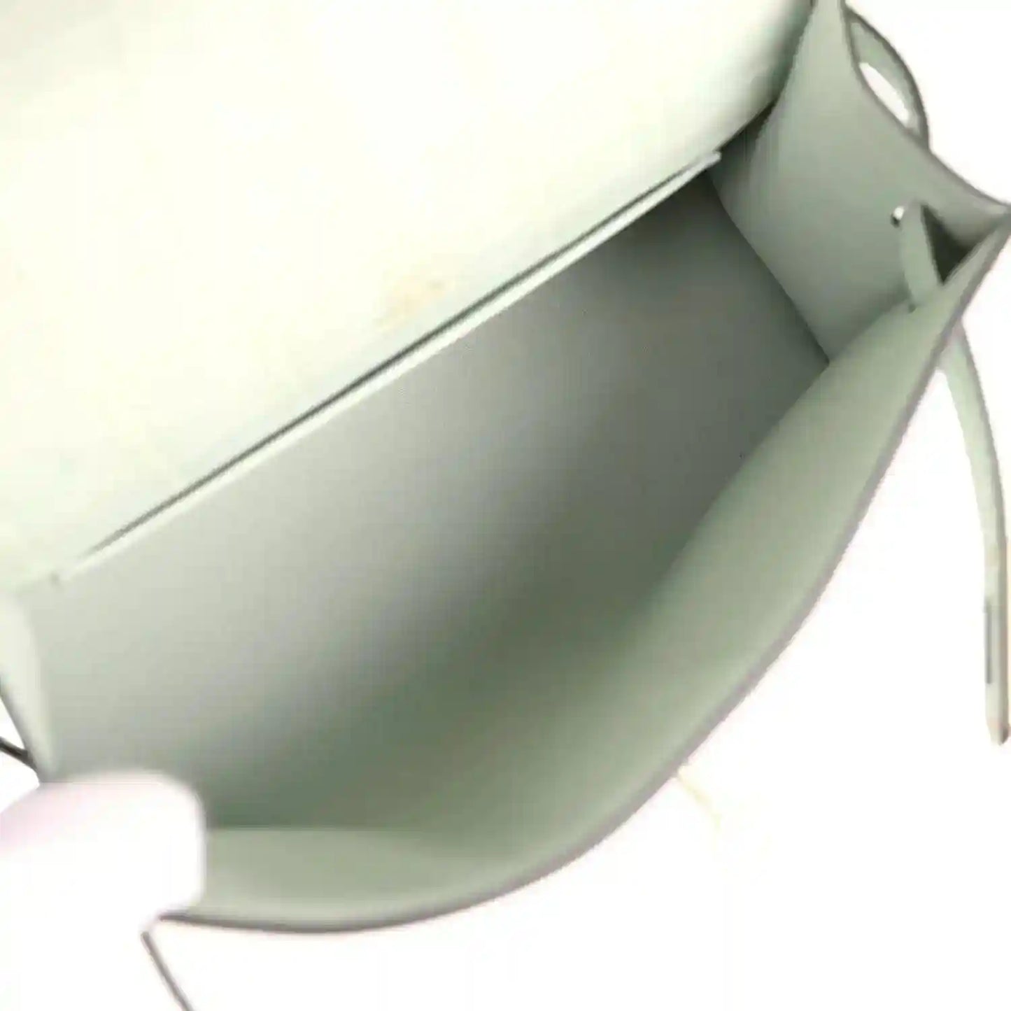 Mint green interior of alligator-style pochette with smooth lining and edge seam