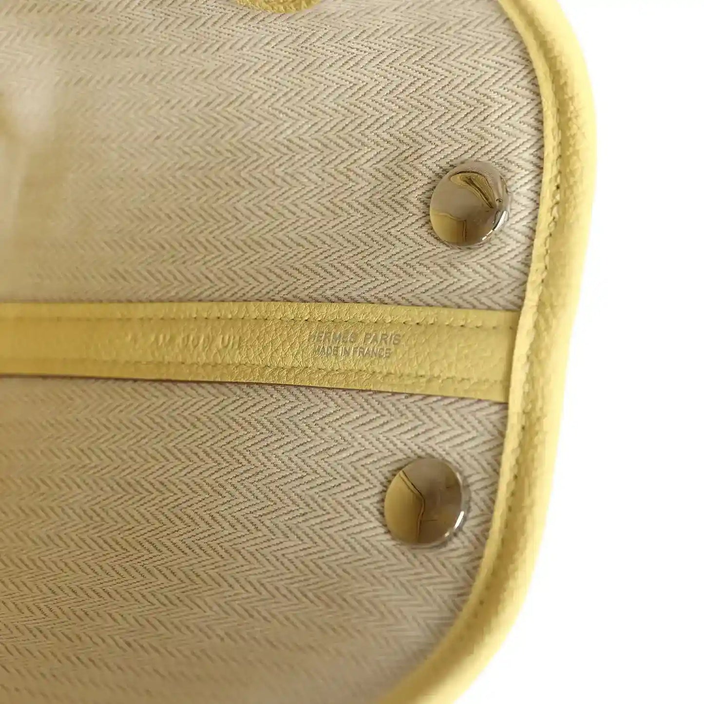 Lined interior compartment with beige herringbone fabric and two snap studs