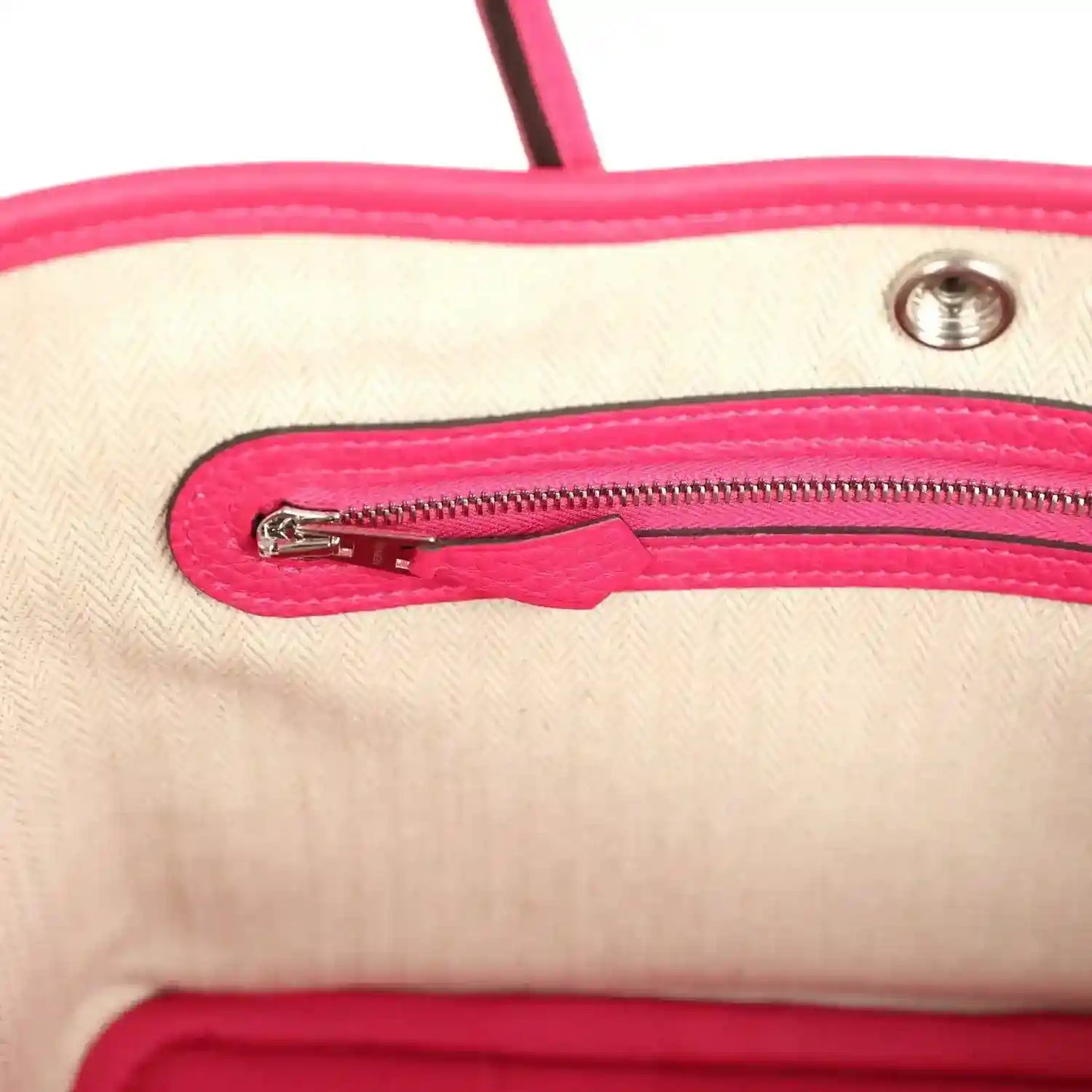 Rose pink leather tote bag interior close-up of zipper with metal pull tab