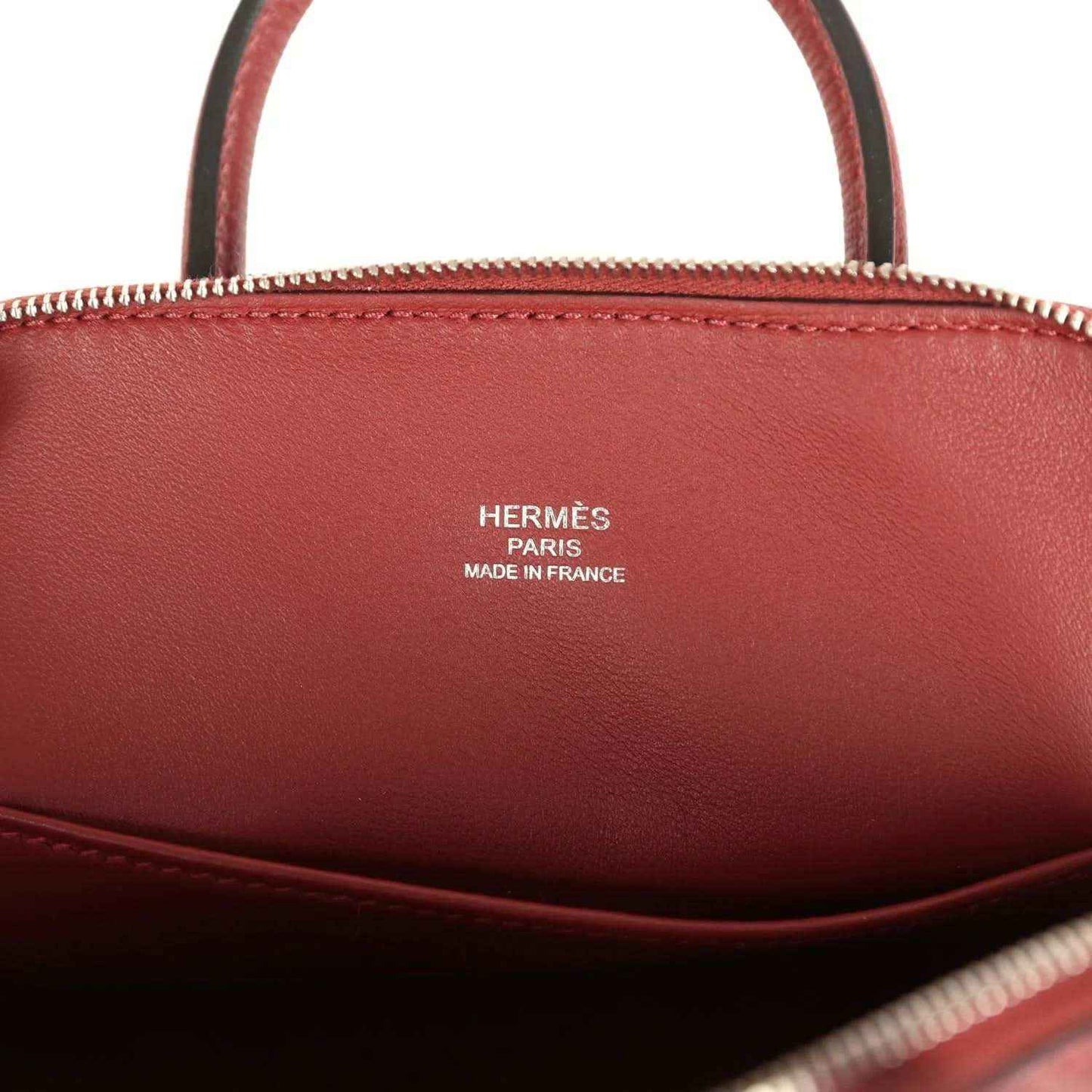 Mini leather handbag interior with HERMÈS Paris Made in France stamp in deep red