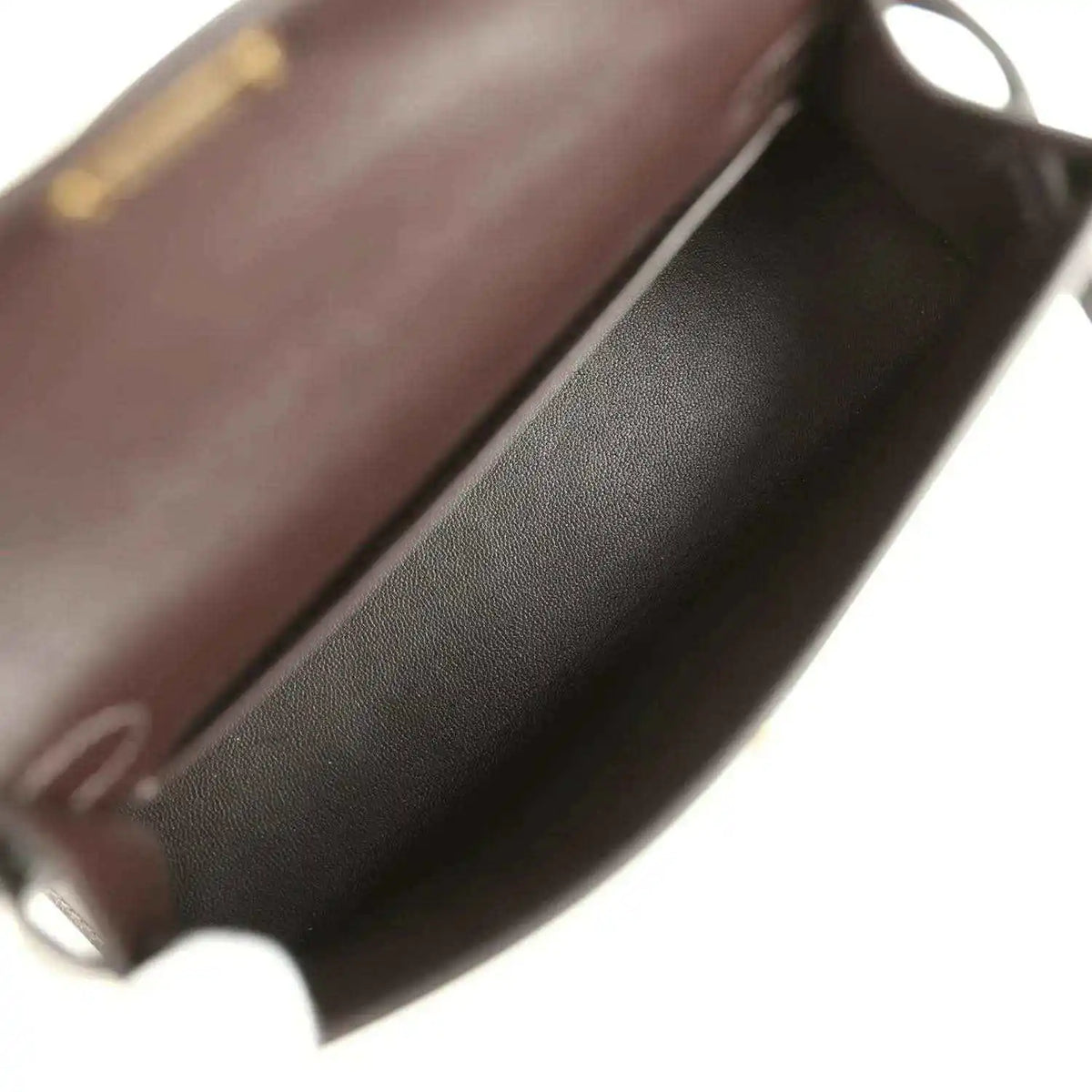 Dark leather interior of a mini bag with smooth lining and curved edge