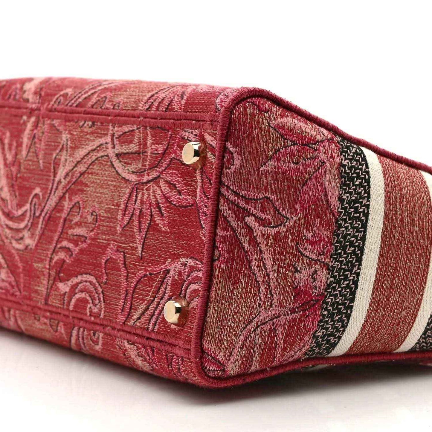 Pink embroidered canvas handbag side panel with gold snaps and striped trim