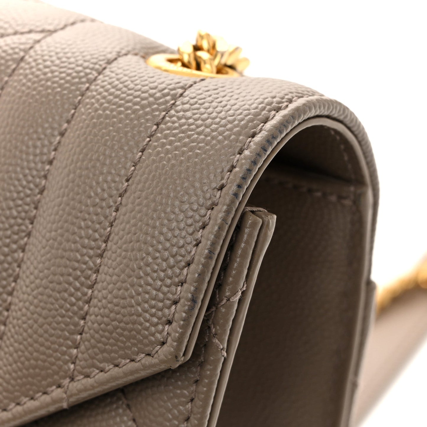 Top flap edge of quilted satchel with stitched panel