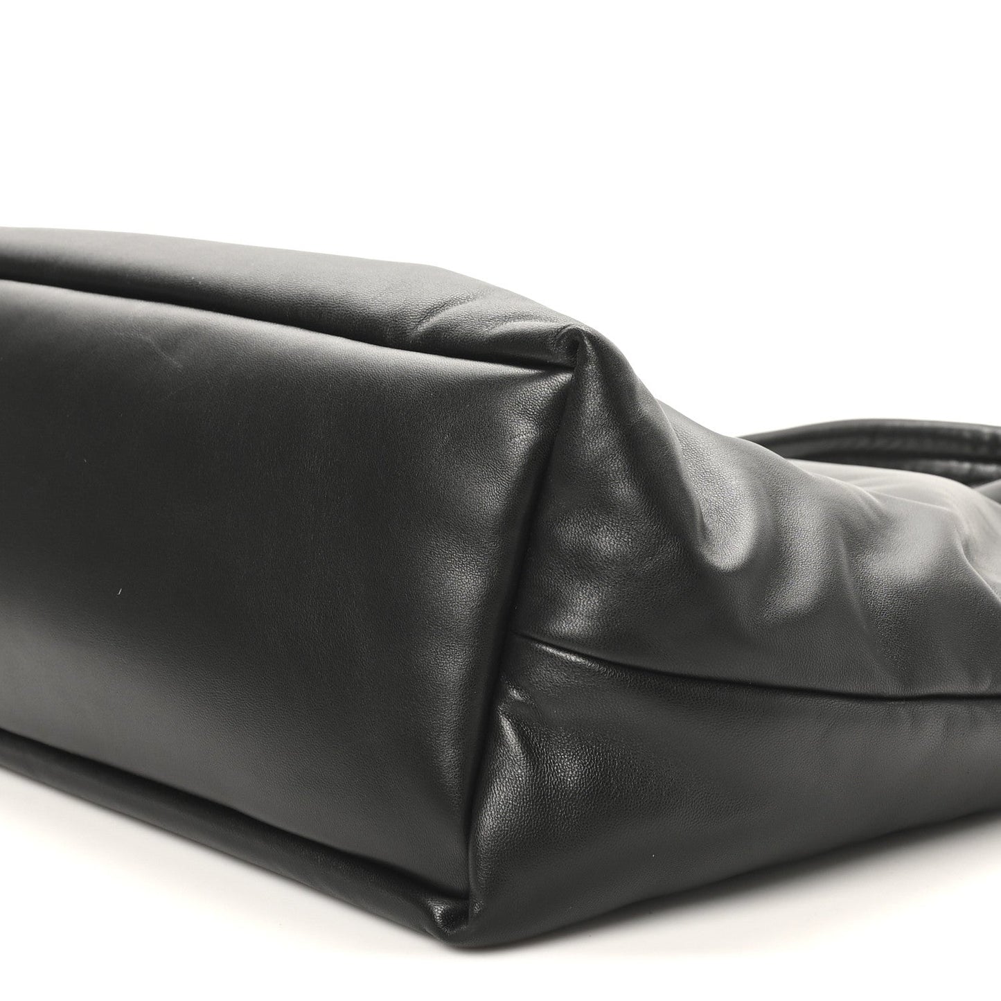 Black lambskin tote side panel close-up with top handle base and seam detail.