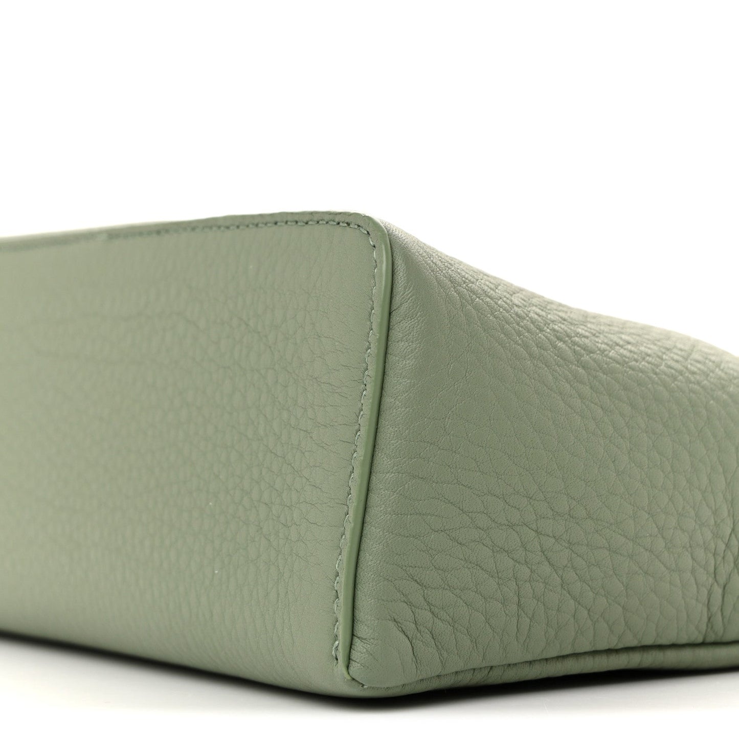 Sage green grained calfskin pouch side panel with edge stitching, close-up