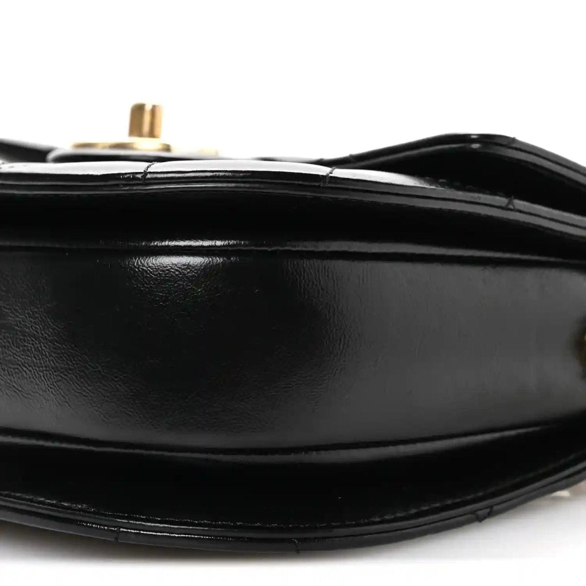 Black leather bag bottom edge with stitching and gold-tone post on top