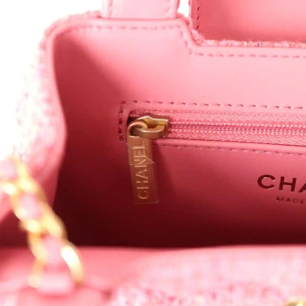 Pink leather interior with CHANEL-tag zipper pull and gold-tone hardware