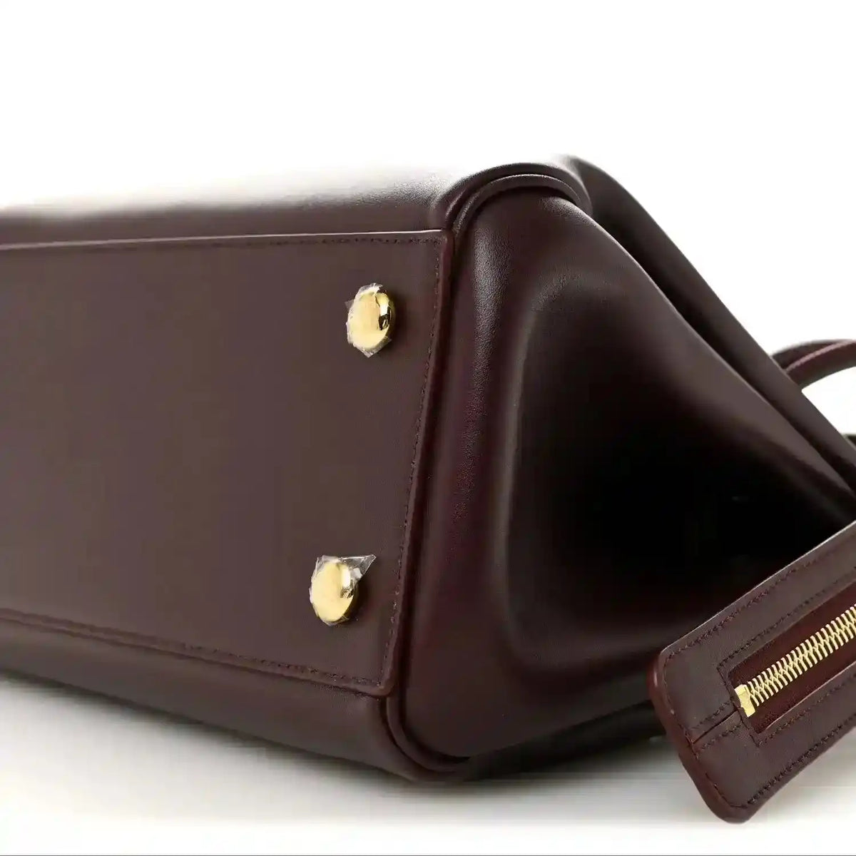 Loewe Small Madrid bag corner close-up in dark burgundy calfskin with strap and zipper