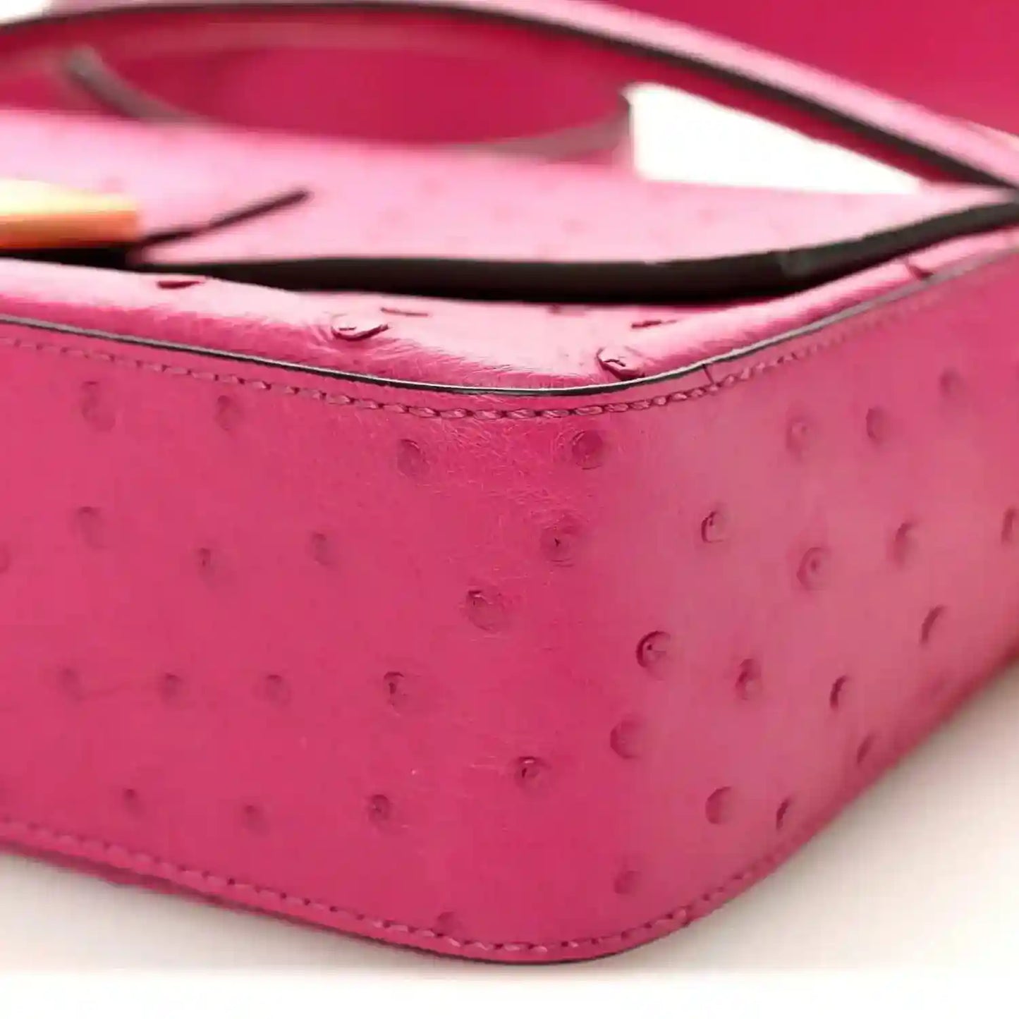 Pink ostrich leather baguette corner with curved seam and black piping