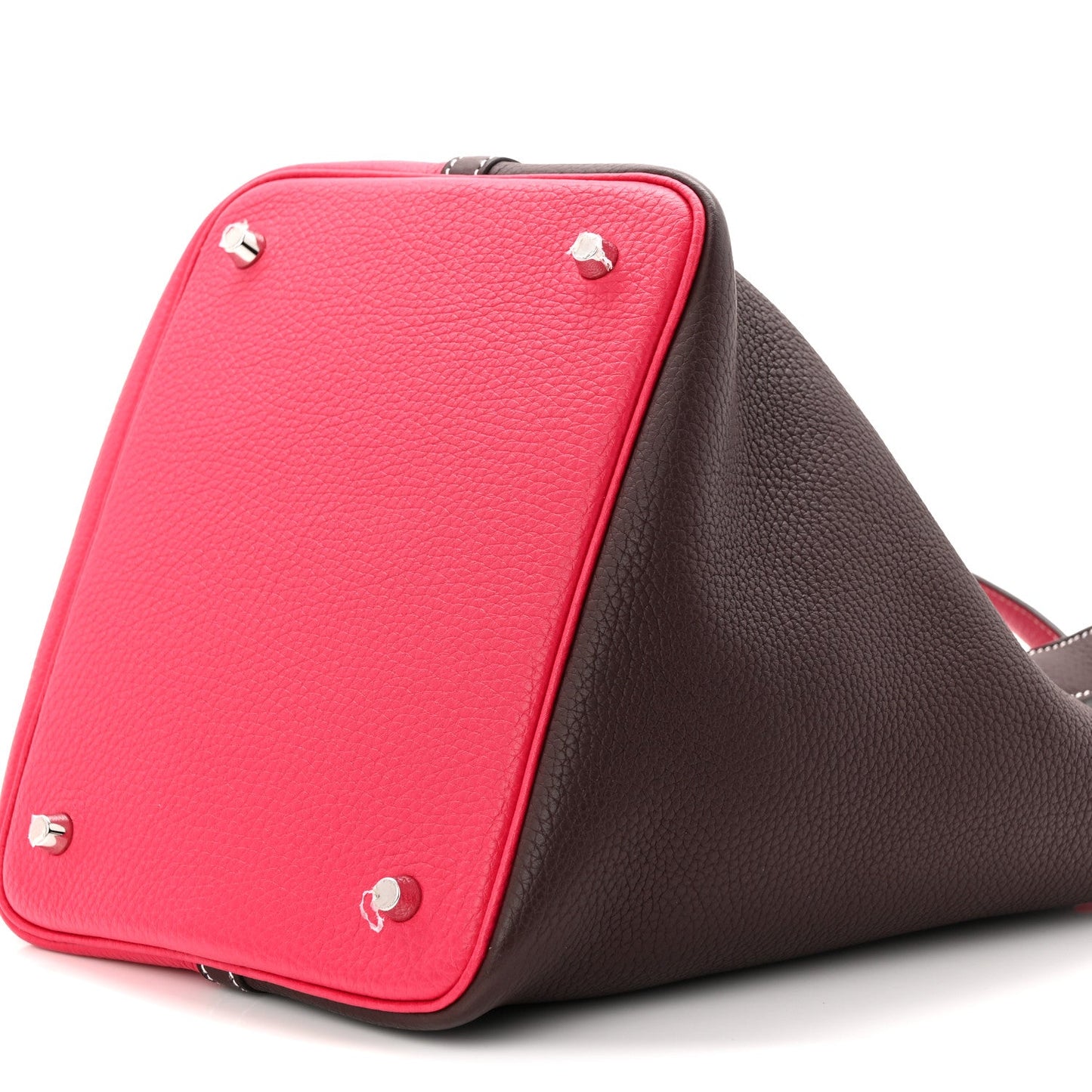Two-tone bucket bag with bright red top and dark brown side panel, corner studs and trim