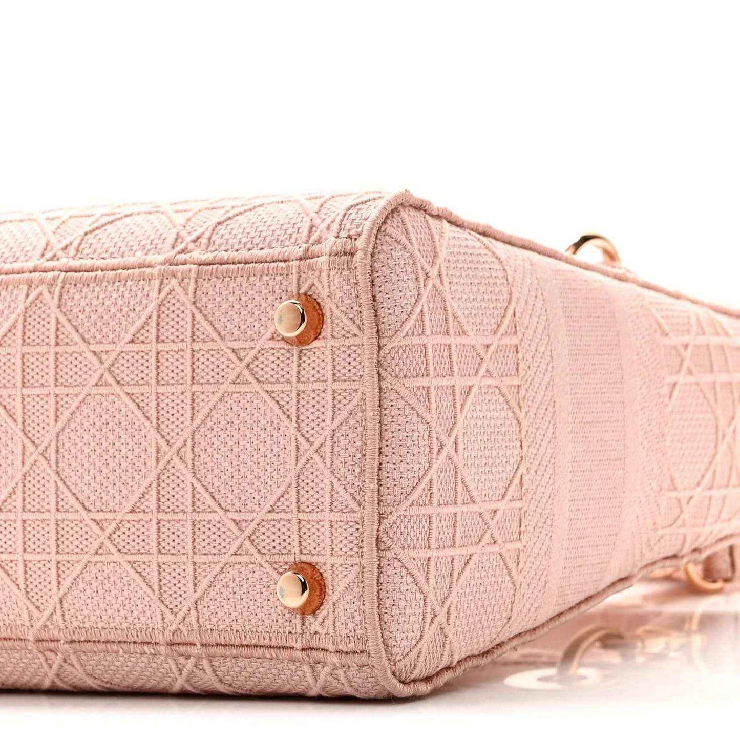 Pink canvas bag side panel with gold snaps and textured geometric embroidery
