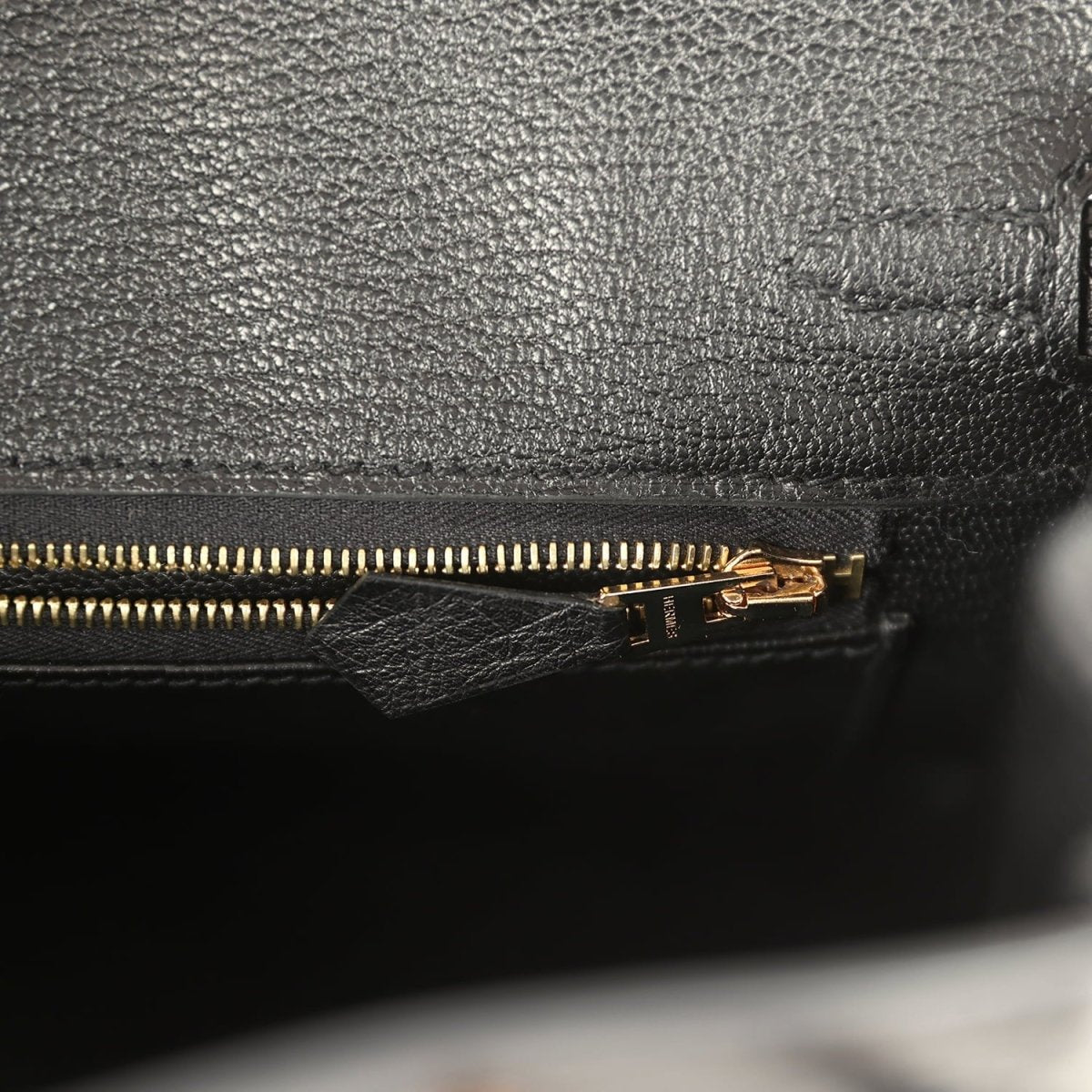 Black leather interior with gold-tone zipper teeth and slider
