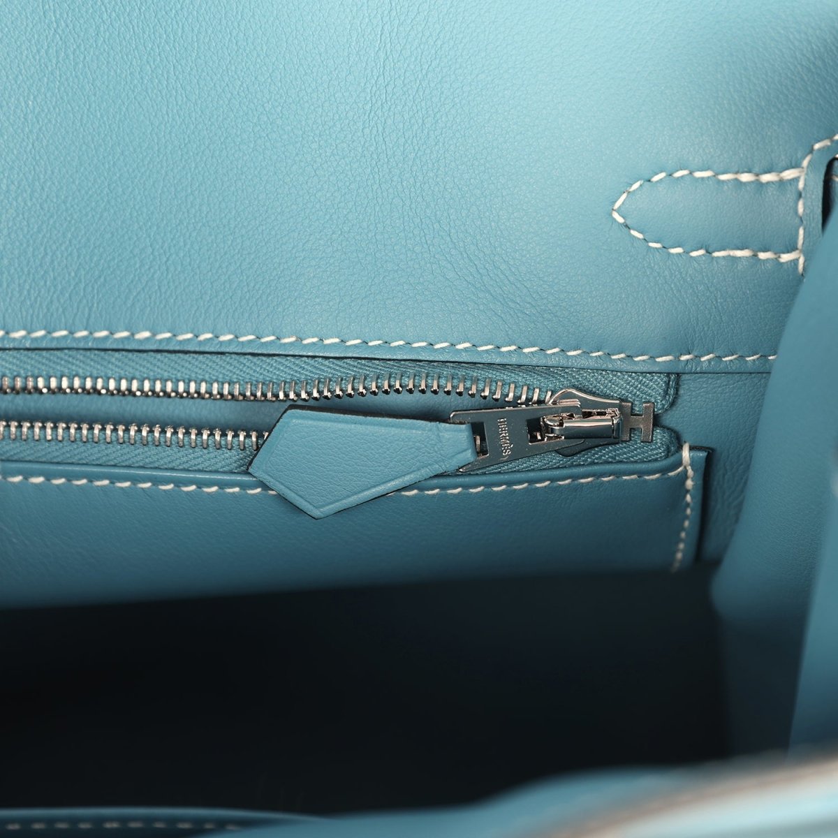 Blue Birkin 25 handbag interior view of zipper track and stitched edge