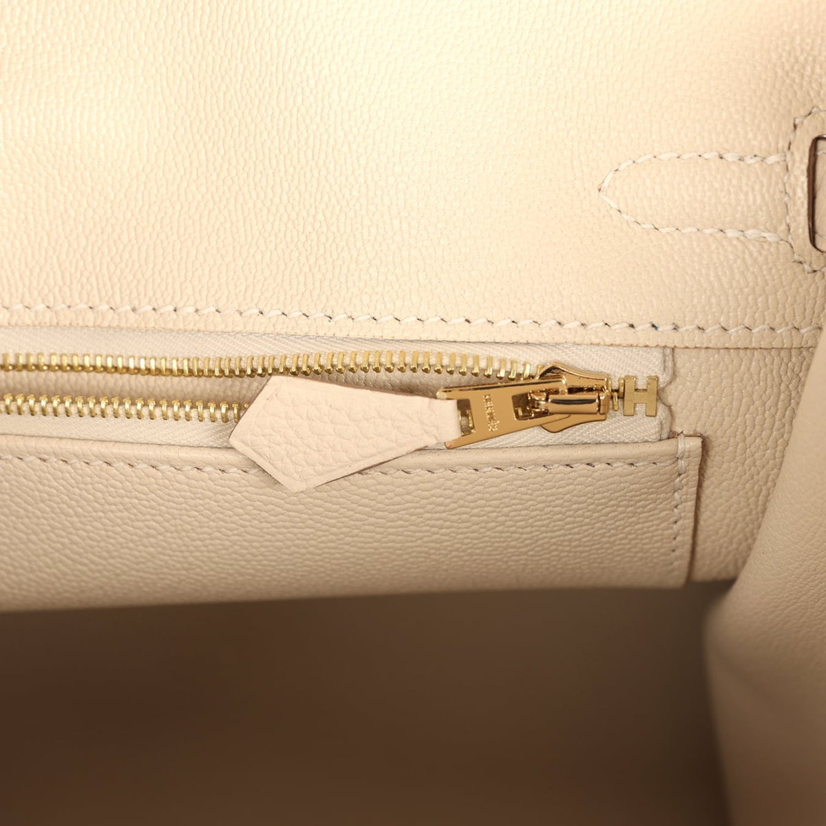 Birkin 25 handbag interior zipper track in light cream leather with gold zipper pull