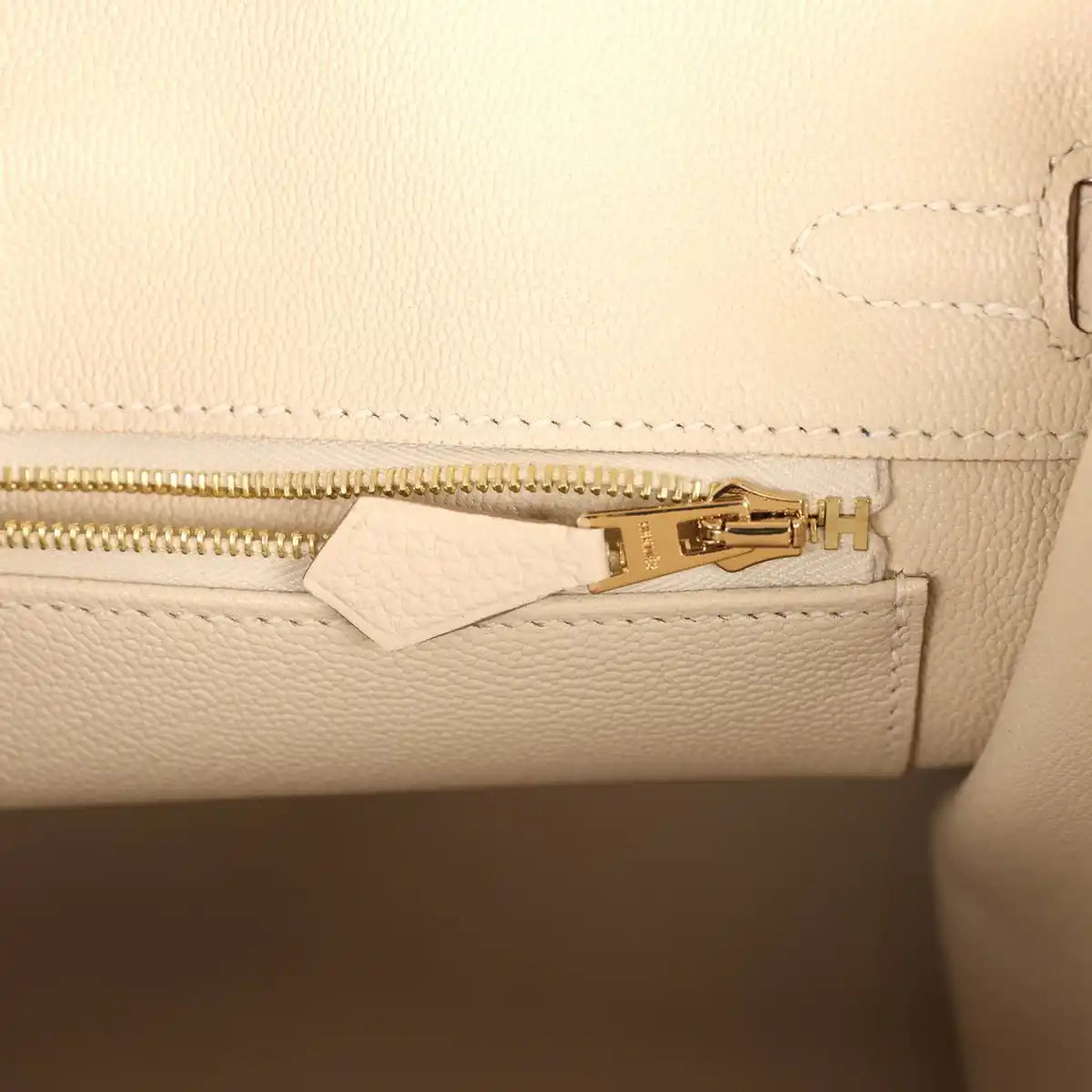 Birkin 25 handbag interior zipper track in light cream leather with gold zipper pull