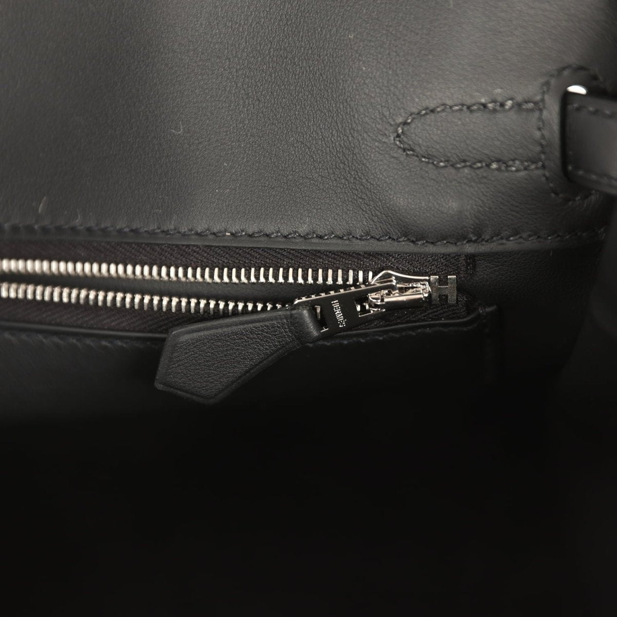 Black leather Hermes Birkin 25 interior pocket with zipper and leather tab pull.
