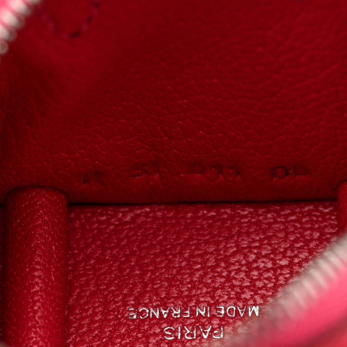 Red leather bag charm close-up with embossed "MADE IN FRANCE" text