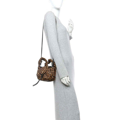 Leopard-print mini spy bag on a light gray sleeve, with black shoulder strap.