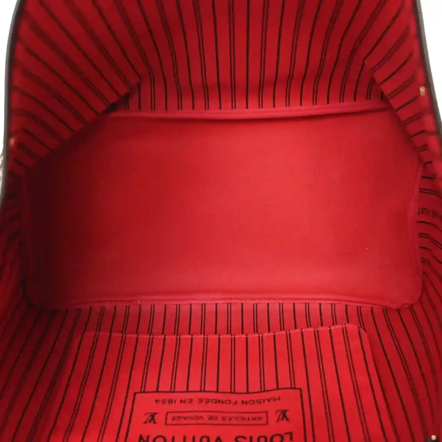 Red fabric interior of the tote bag with stitched lining along the open top