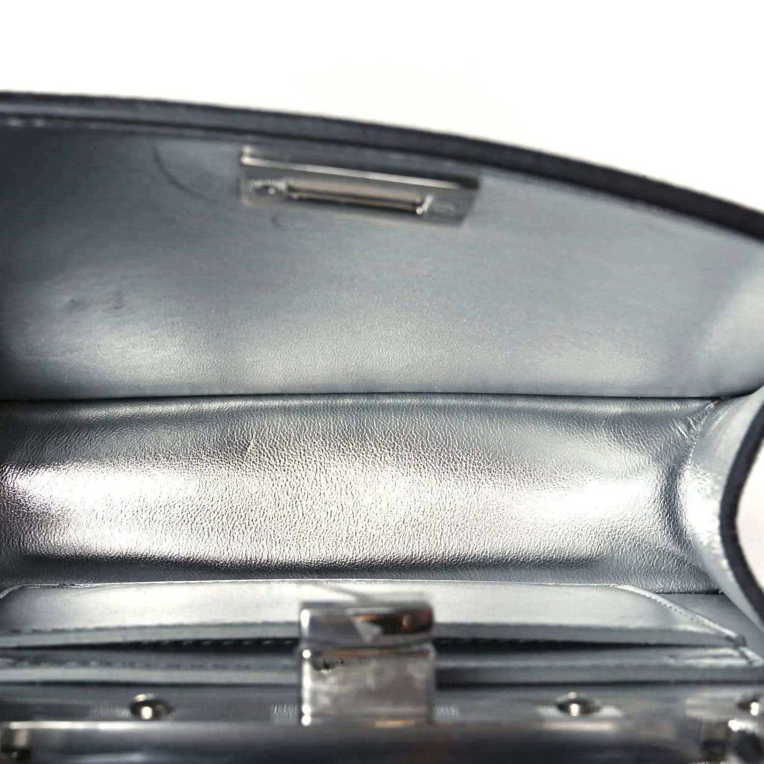 Satchel interior flap with rectangular metal clasp and dark leather lining