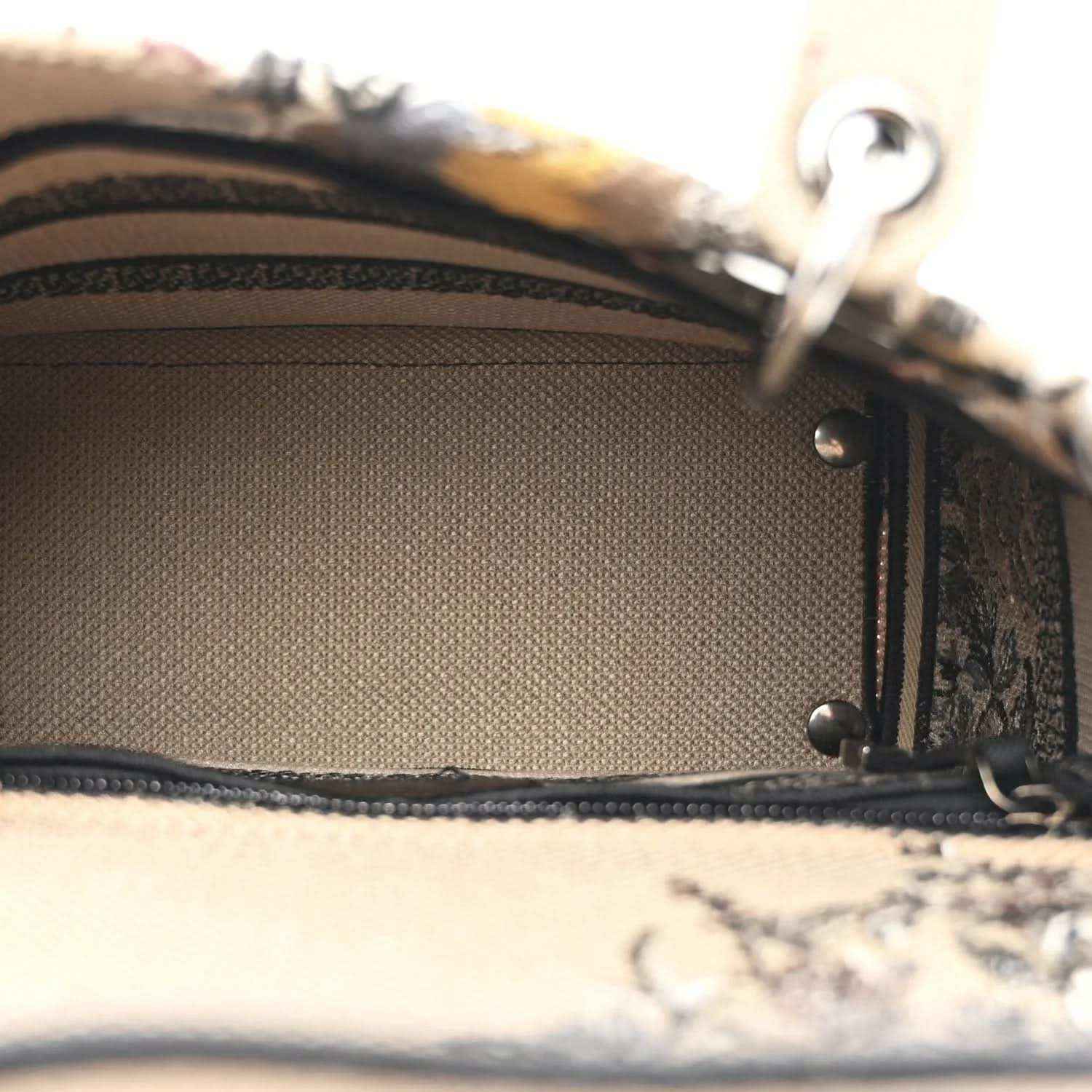 Canvas bag interior lining with stitched edge and metal strap hardware.